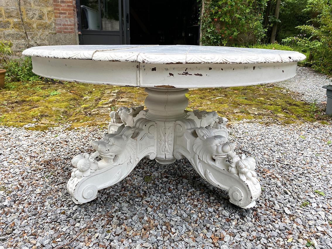 Table en chêne laqué blanc, pied central richement sculpté. Fin XIXe
Fût central reposant sur quatre pieds sculptés à décor d’animaux et de fruits montés sur roulettes.
Plateau ovale s’ouvrant pour accueillir plusieurs rallonges (rallonges non