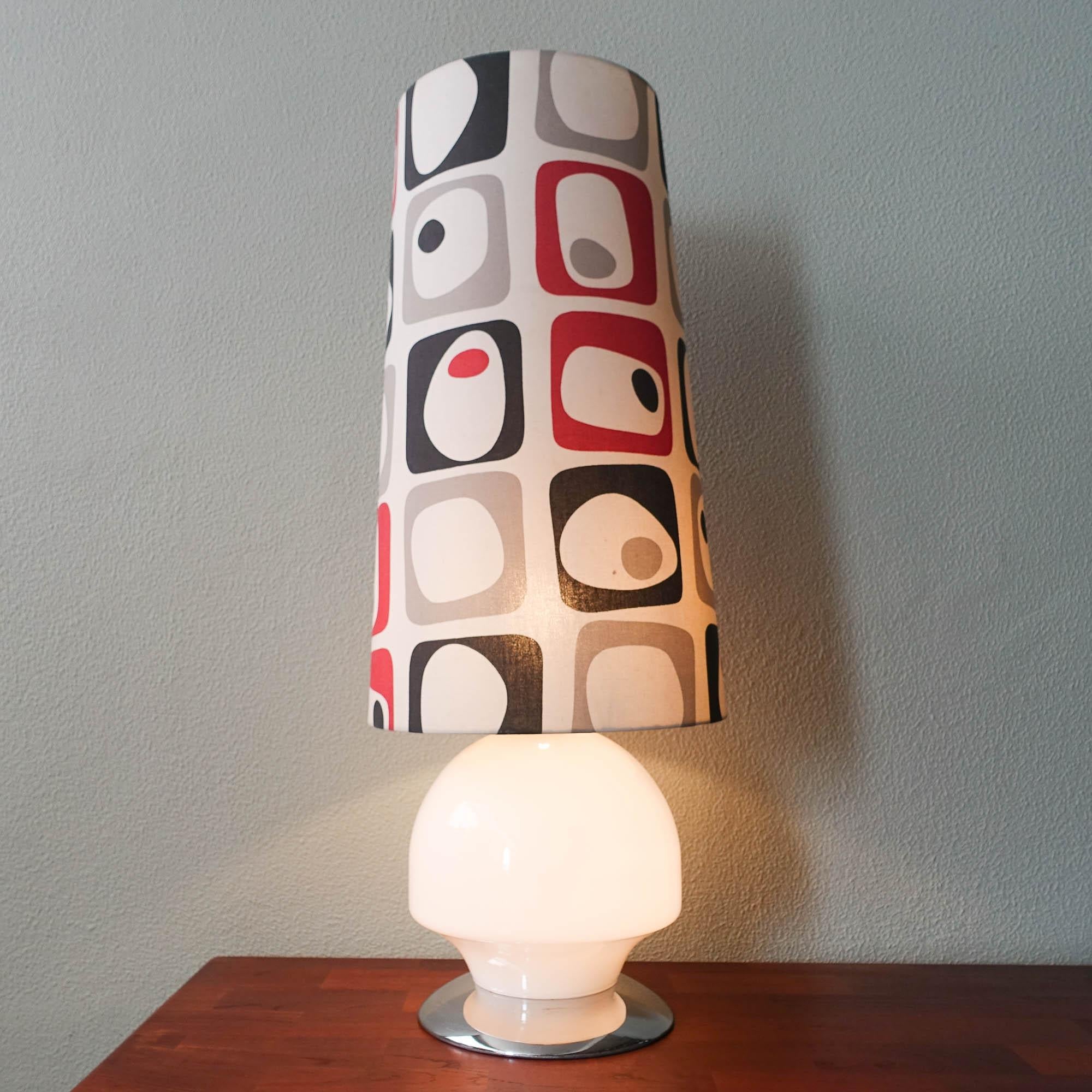 This table/ floor lamp is original from the 1960's. It was produced in Portugal, by Marinha Grande Glass Factory. It has a chrome metal base, were a white glass base is set. Dividing the base and the top is a chrome metal piece, were sets the fabric