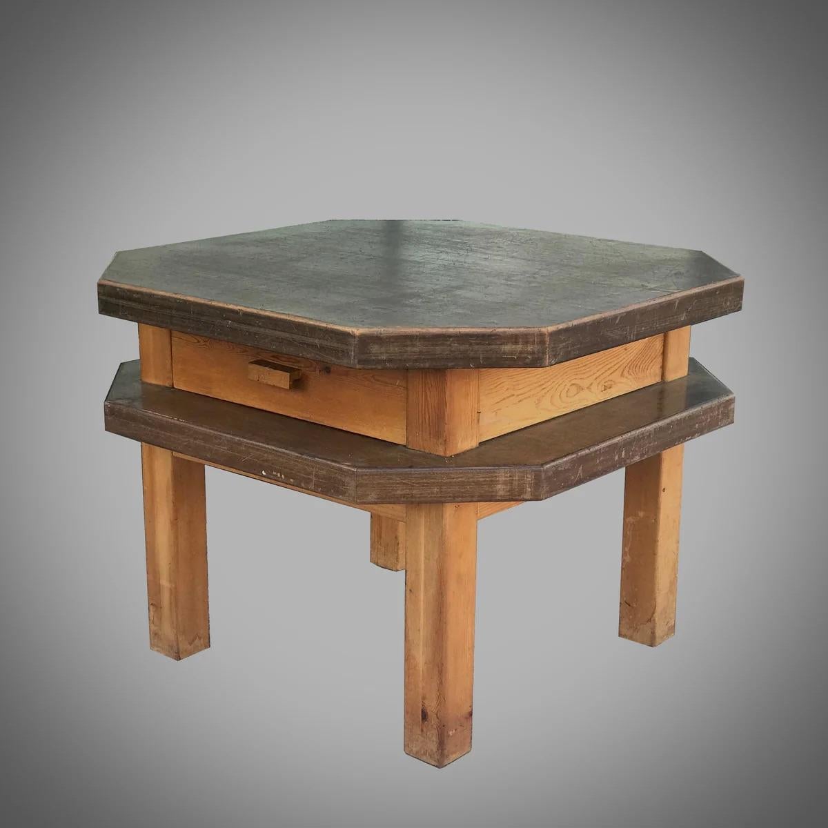 Esta mesa octogonal moderna de mediados de siglo, procedente de España, combina funcionalidad con un atractivo estético único. Fabricada en nogal, la mesa presenta un distintivo diseño de dos niveles, con un sencillo friso que alberga un único