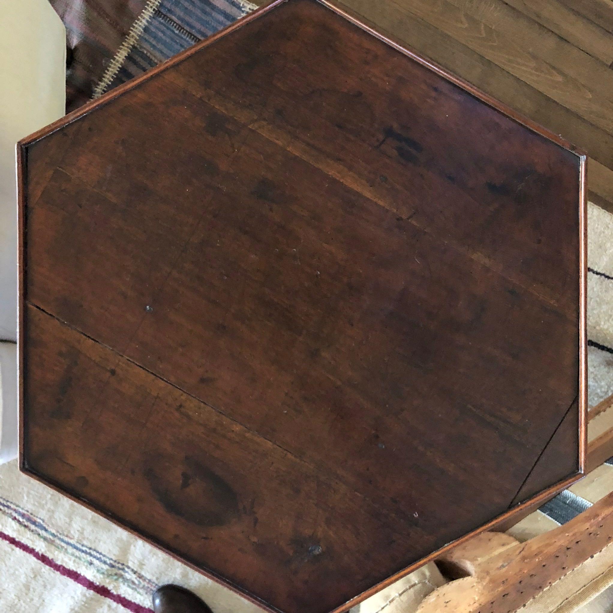 18th-century English octagonal wooden side or occasional table. This lovely Georgian piece features an octagonal top mounted on three winged legs and a small octagonal lower shelf. Delicate yet sturdy and classic, the piece would work in a variety