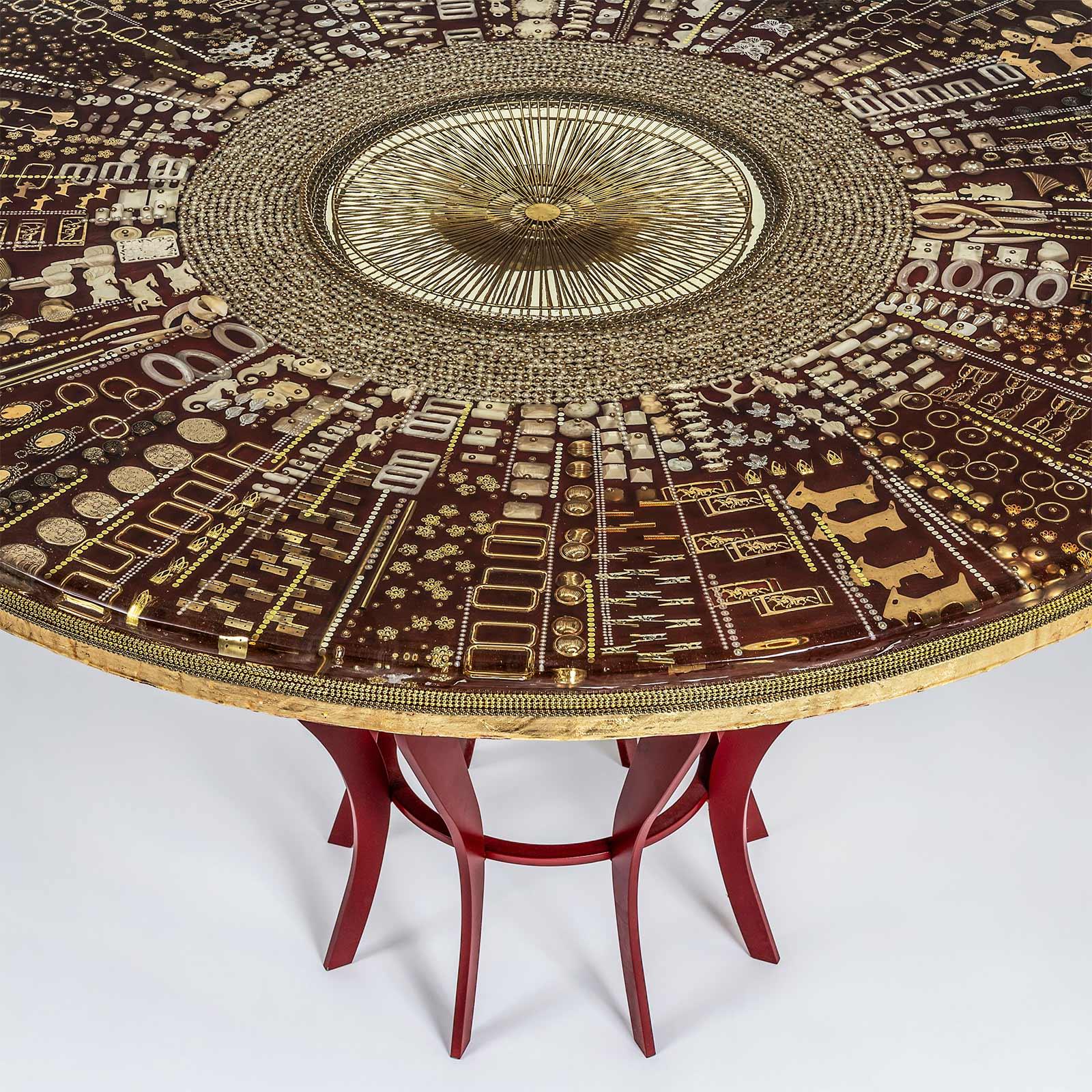 Handmade round table in resin and iron. A 3d composition made using different layers of resin. Each layer contains different kinds of objects, mixing precious material like gold, brass and small daily objects like pin, buttons, chopsticks and many