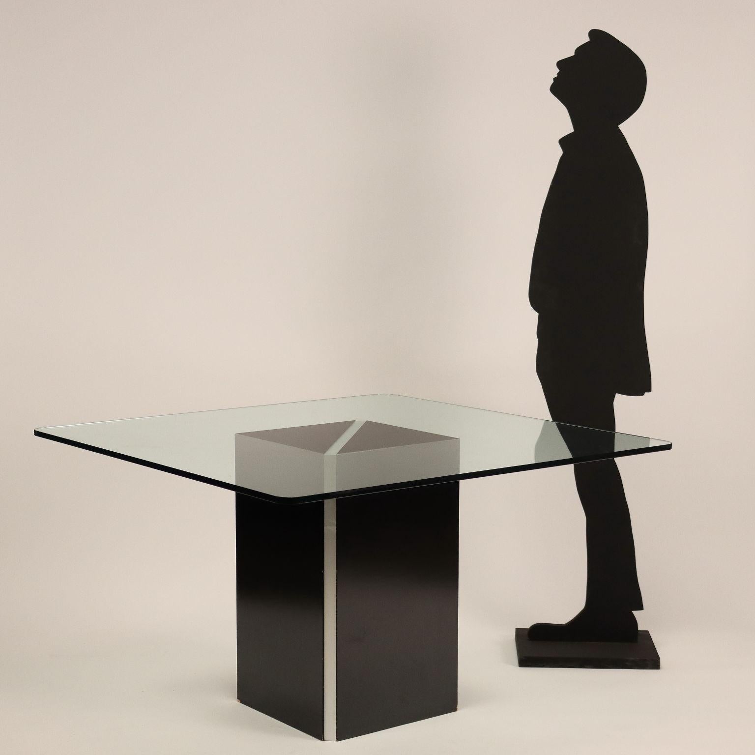 Table with base in lacquered wood and lamina in chromed aluminum, top in glass.