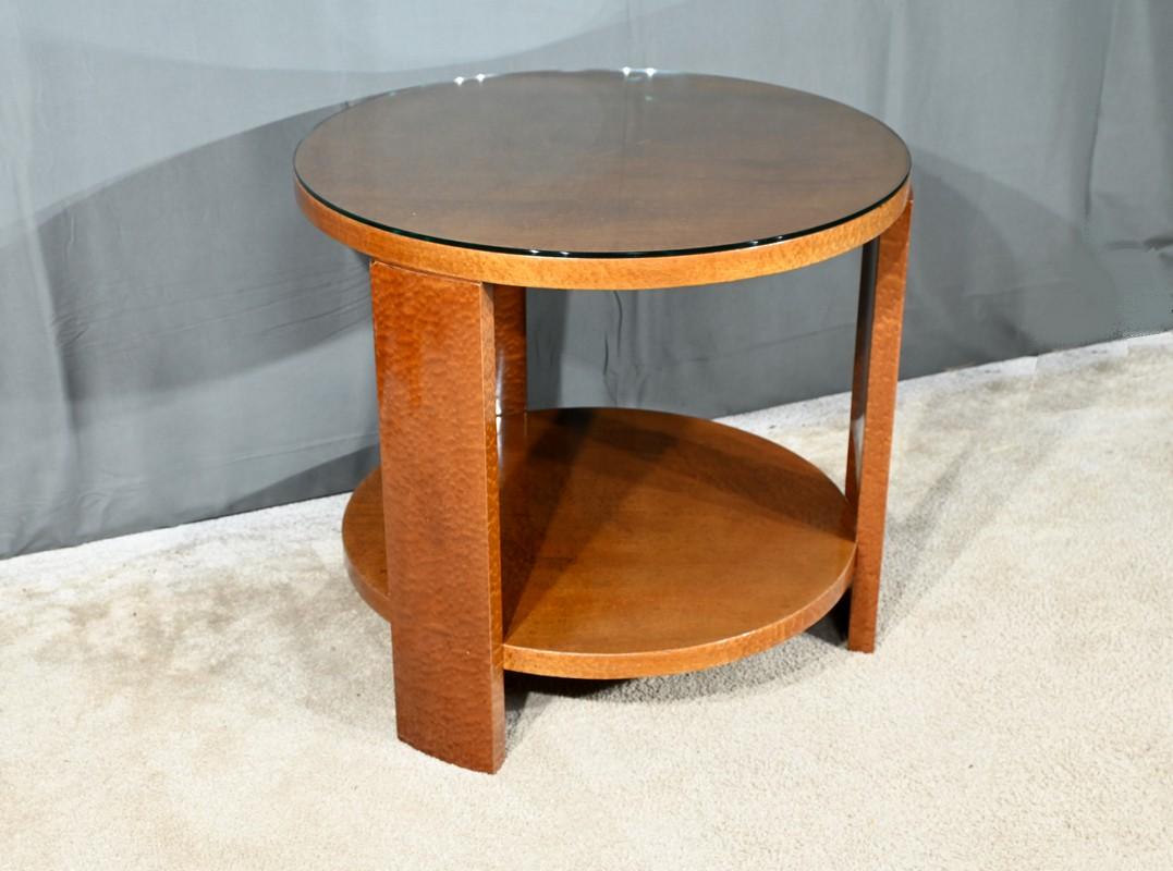 Ce guéridon, datant de la période Art déco des années 1930, est un parfait exemple de design minimaliste et raffiné.
Fabriqué en loupe d'amboyna, un bois précieux connu pour ses veinures uniques, il incarne le luxe discret et l'élégance de