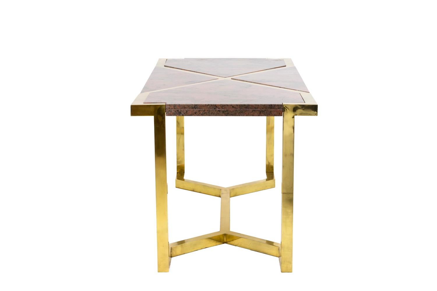 Table in gilt brass and pink granite in the style of Cittone Oggi or Nucci Valsecchi. Table standing on four square-shaped legs linked to each other by an X stretcher. 
Tray composed of a gilt brass frame in the line of legs, also forming an X in