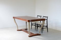 Table in veined walnut with legs in the shape of an elephant tusk
