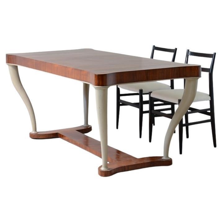 Table in veined walnut with legs in the shape of an elephant tusk