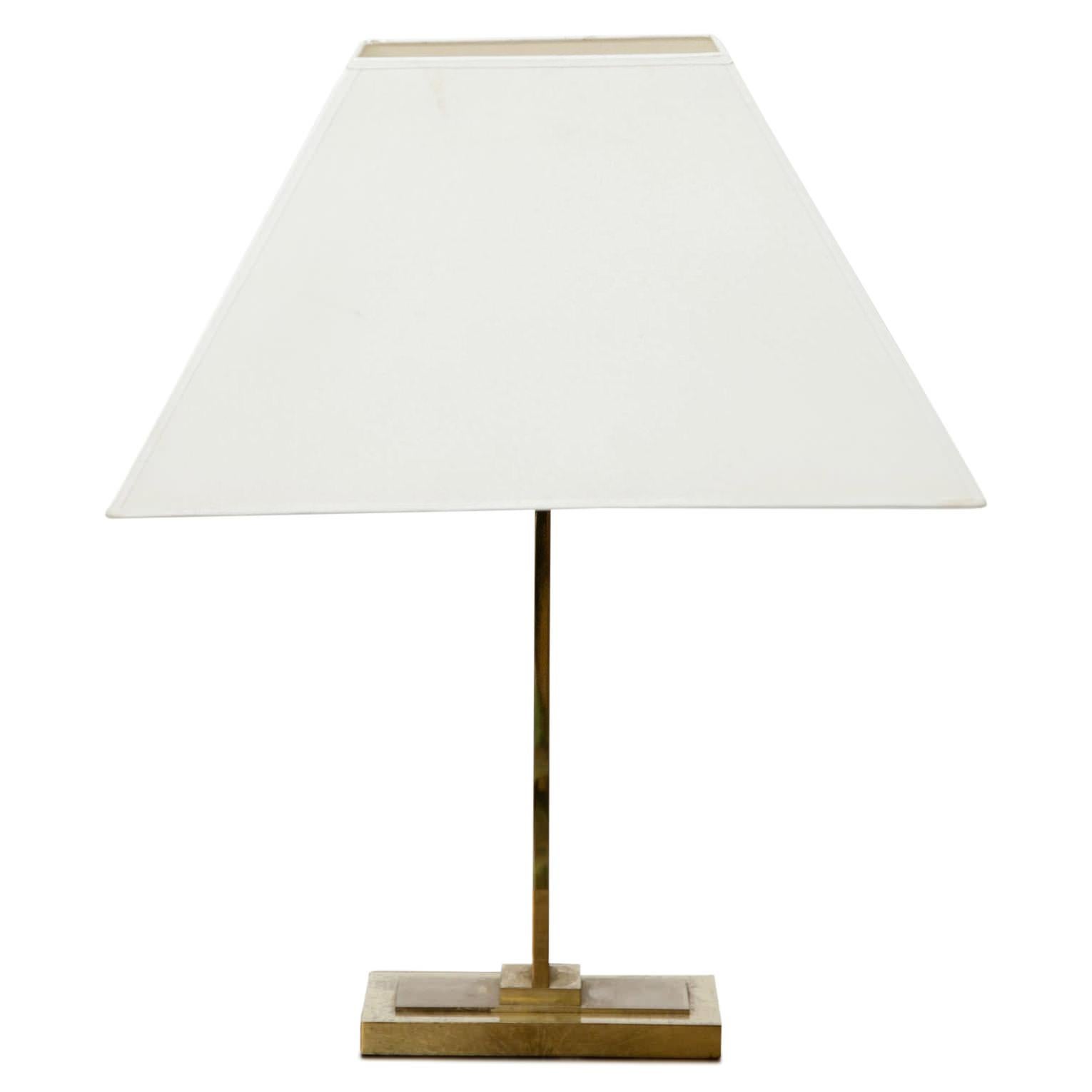 Table lamp with a white cloth lampshade, a rectangular brass foot and a shaft with thick, faceted glass panes. 

For the electrification we assume no liability and no warranty.