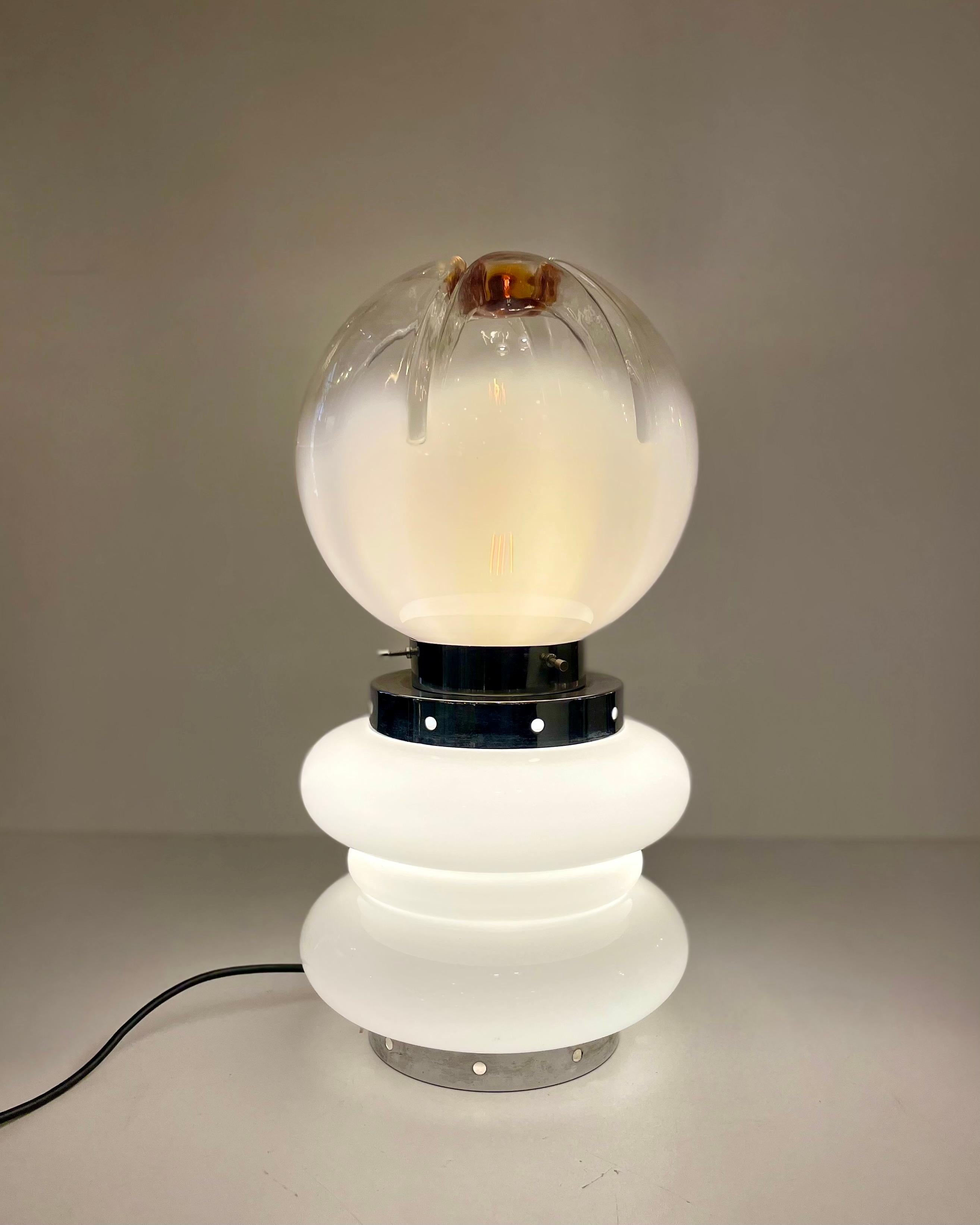 Italian table or floor lamp, made of two parts of Murano glass, all white on the bottom and white gradient with an orange marron spot above on the top part, united by chromed metal parts. Possessed a double light source that can be light-up all