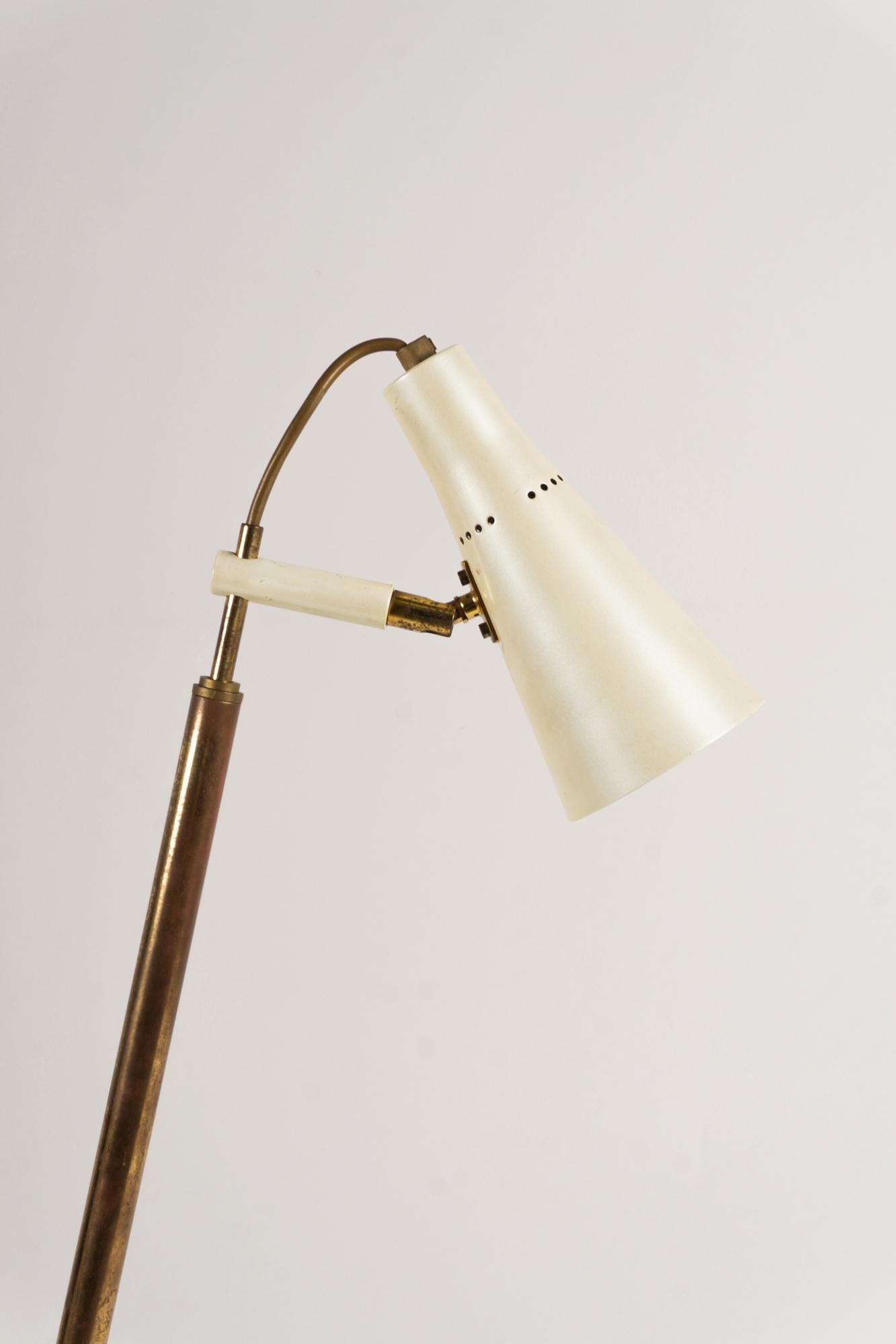 This desk / floor lamp is attributed to Giuseppe Ostuni / O-Luce. Made around 1955 from brass with a mother-of-pearl lacquer finish and the reflector is made of aluminum. The height of the lamp can be adjusted from 70 cm to a maximum of 142 cm.