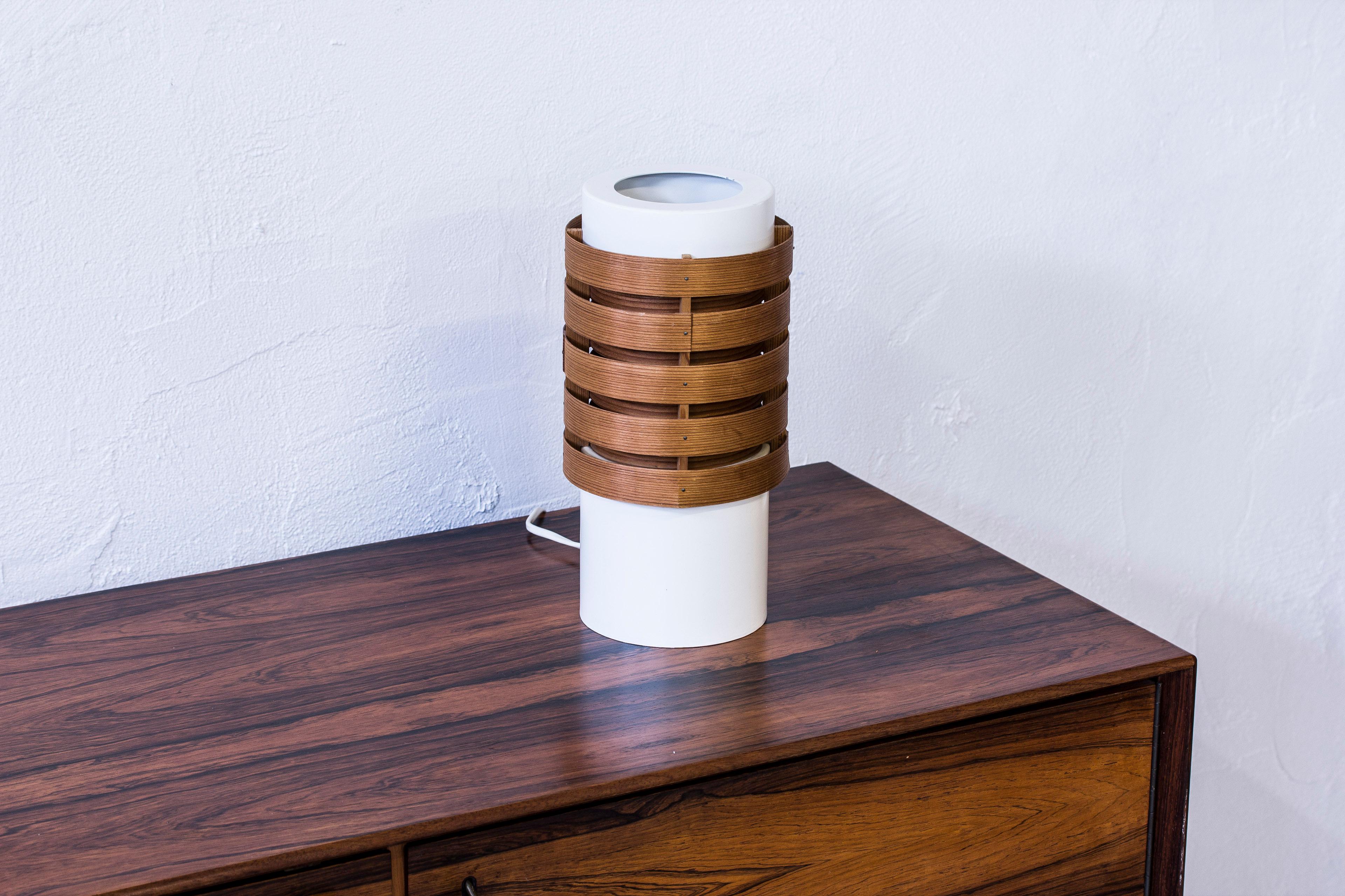 Very rare table lamp model B108 designed by Hans Agne Jakobsson. Produced by Ellysett in Sweden, circa1965. Made from white lacquered aluminium and pine veneer. Signed with label and impressed burn mark on the wooden part. Very good condition with