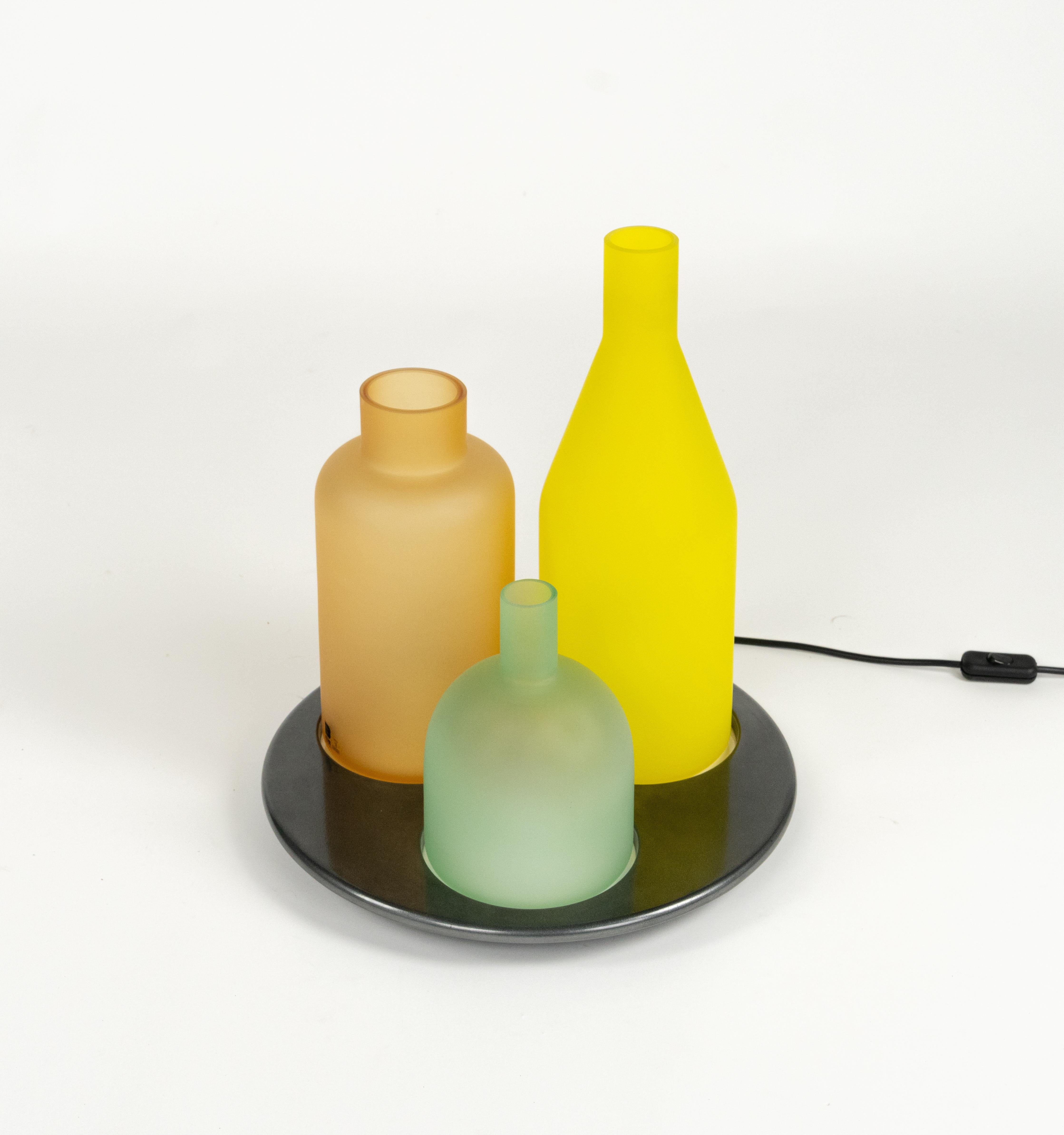 Bellissima lampada da tavolo in vetro di Murano e metallo di Guido Rosati per ITRE.

Realizzato in Italia negli anni '80.

La lampada Bacco è una raffinata espressione del design italiano, composta da tre diffusori a forma di bottiglia in vetro