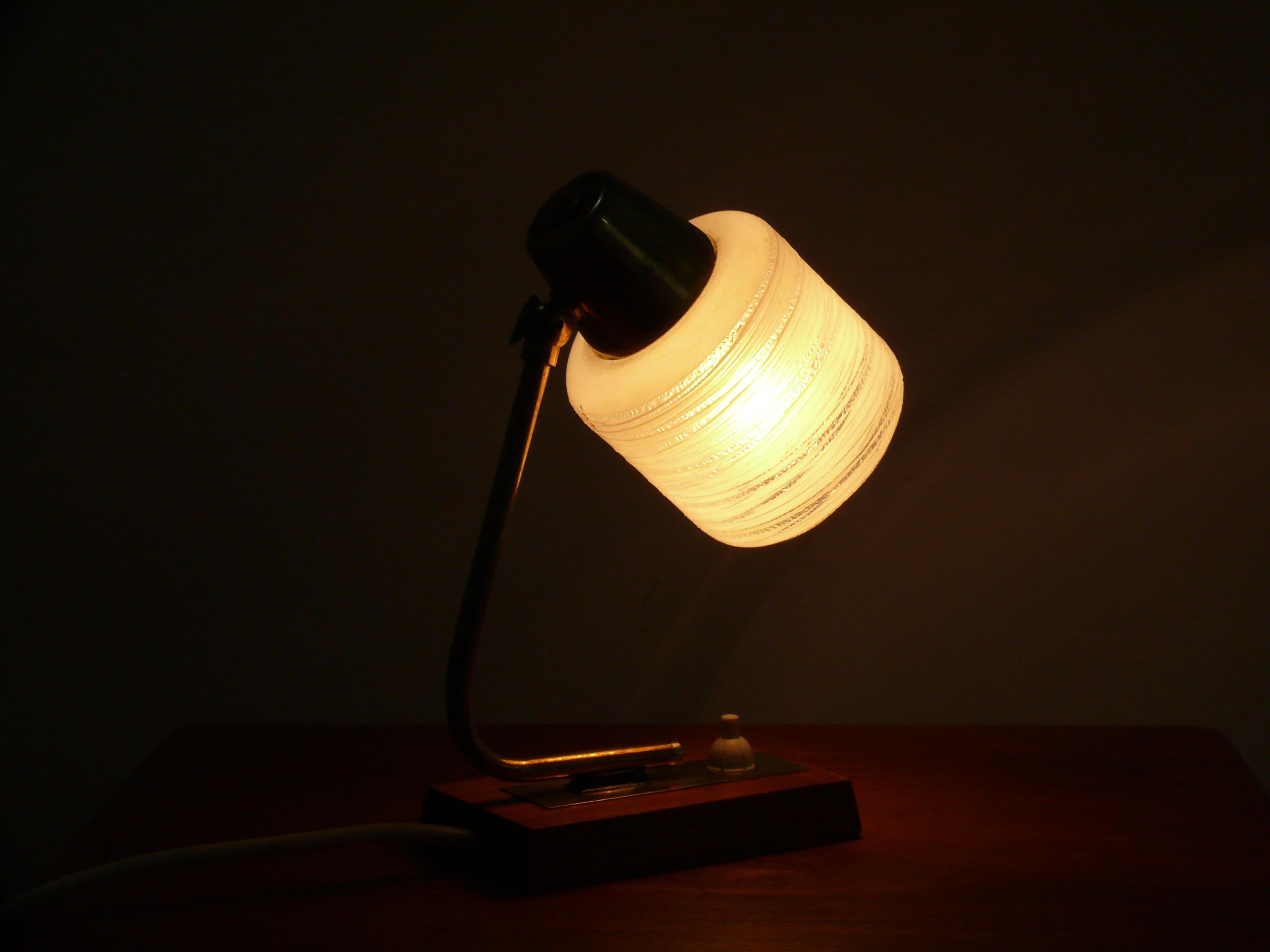 Well-preserved table lamp from the 1960s in Scandinavian style with a teak base and brass holder. The textured opal glass shade – satin white with a delicate radial pattern – provides pleasant, glare-free ambient light and is in good condition. The