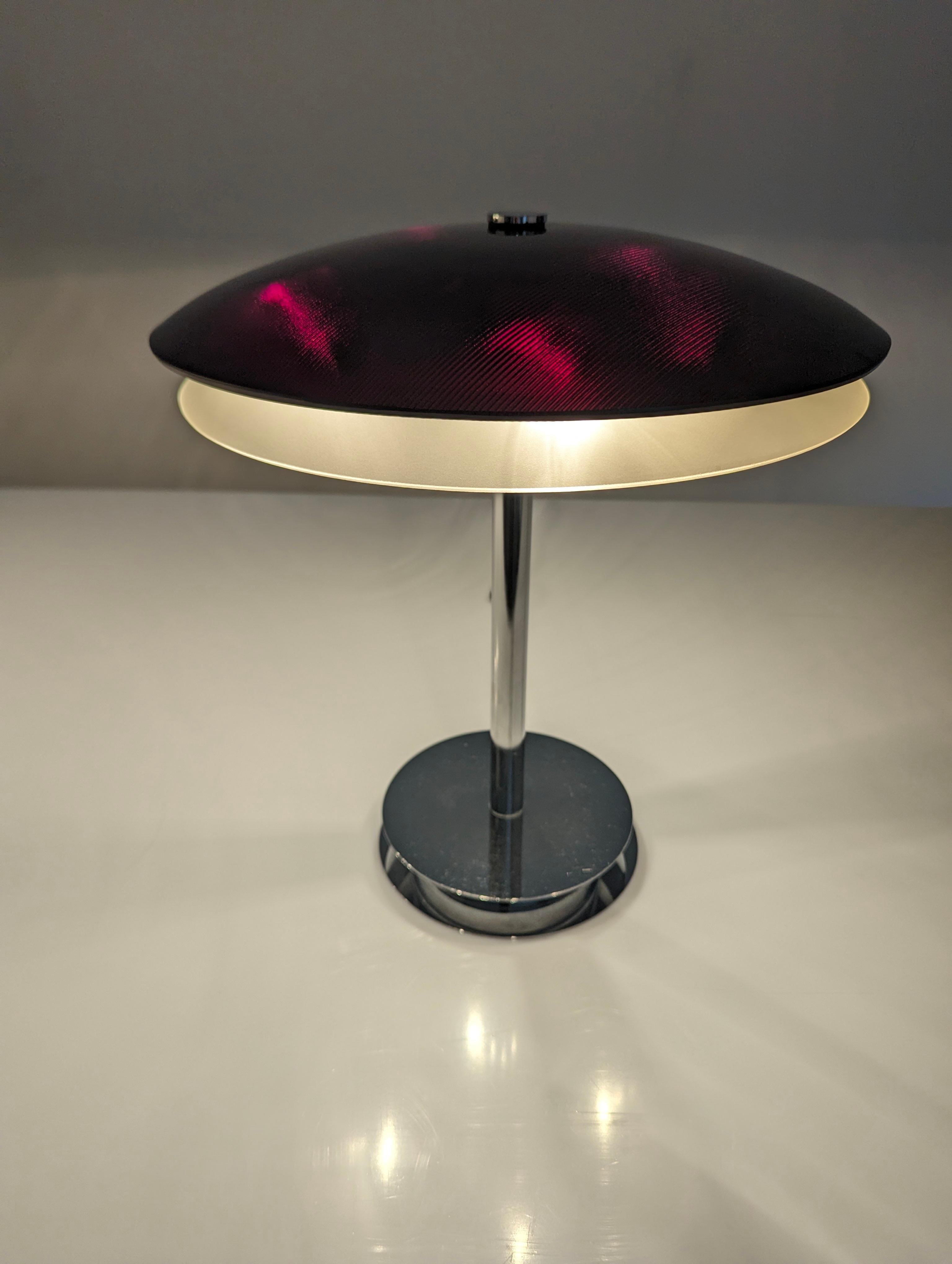 Élégante lampe de table conçue par Fontana Arte en 1954. Base bromée avec double plateau de cristal incurvé en noir avec des reflets rouge bordeaux lorsqu'il est allumé, et en bas blanc translucide qui émet une lumière agréable.