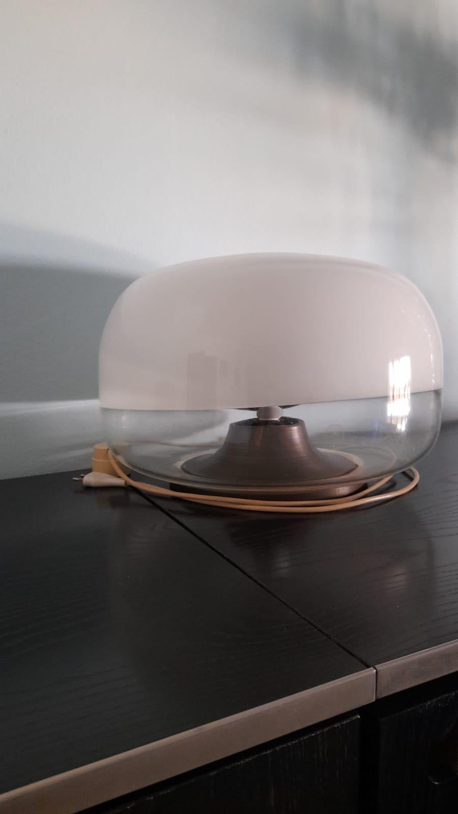 The table Lamp is Italian design model, 1969s from Artemide, the base is in burnished metal, the blown glass Murano is half trasprent and half white. Original code.
I am available for any informatios.