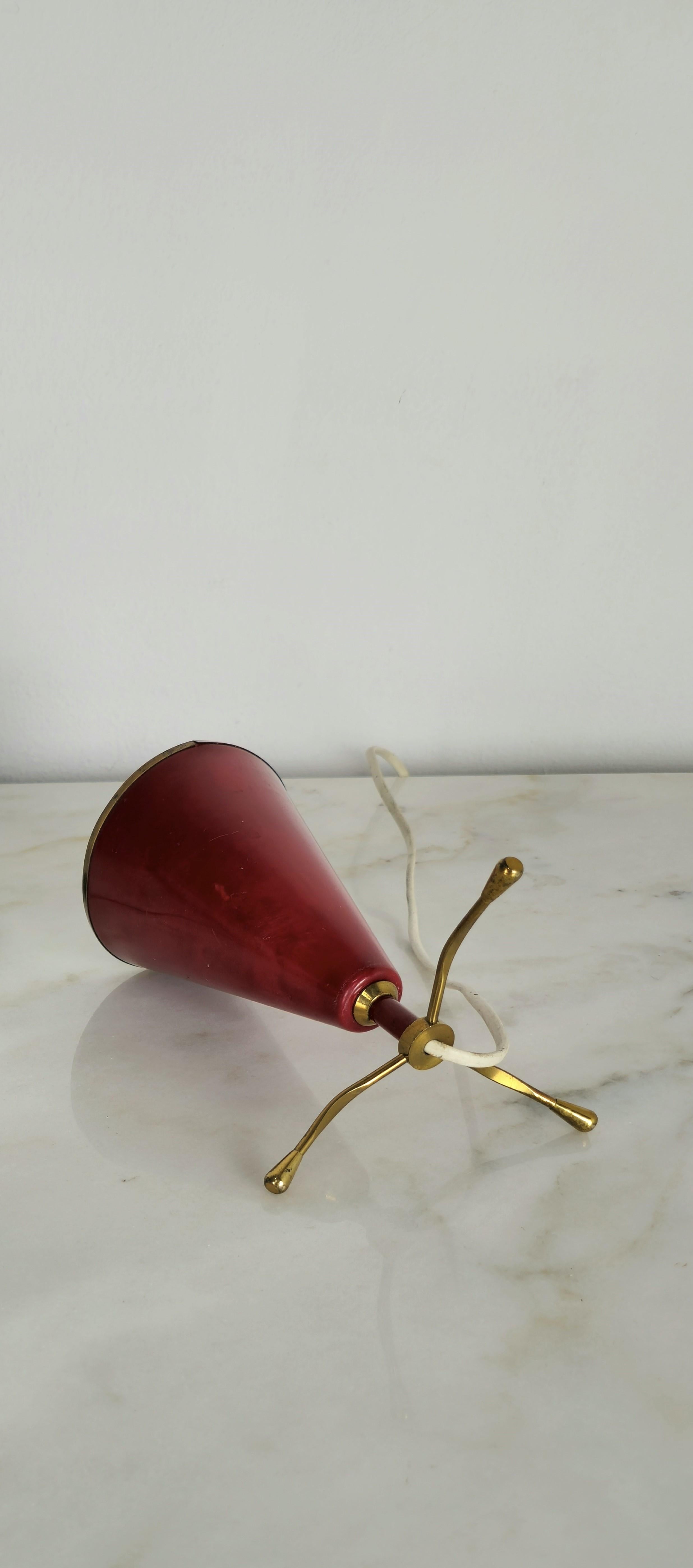 Lampe de table attribuable à Arredoluce, produite en Italie dans les années 1950.
Lampe de table E14 à une seule lumière avec diffuseur conique en aluminium laqué rouge, bordure et 3 pieds en laiton.

Diamètre du diffuseur : 10.5 cm. 
Poids ;  190