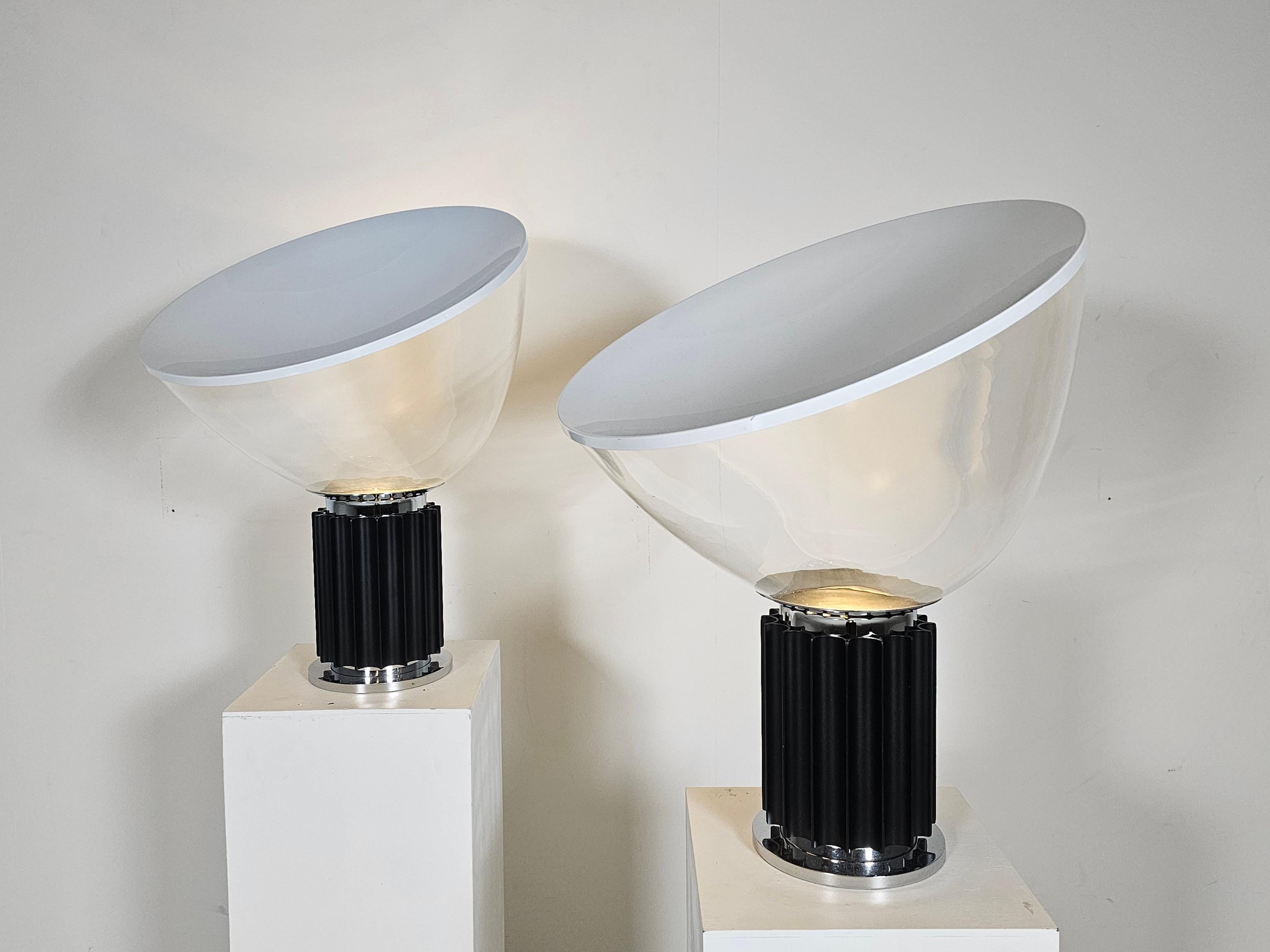 Lámpara Tacci, Achille and Pier Giacomo Castiglioni, Flos, década de 1970.

Lámpara de mesa Taccia con base de acero pulido y niquelado, y cuerpo de aluminio lacado en negro. El difusor de luz regulable se fabricó en vidrio soplado a mano con un