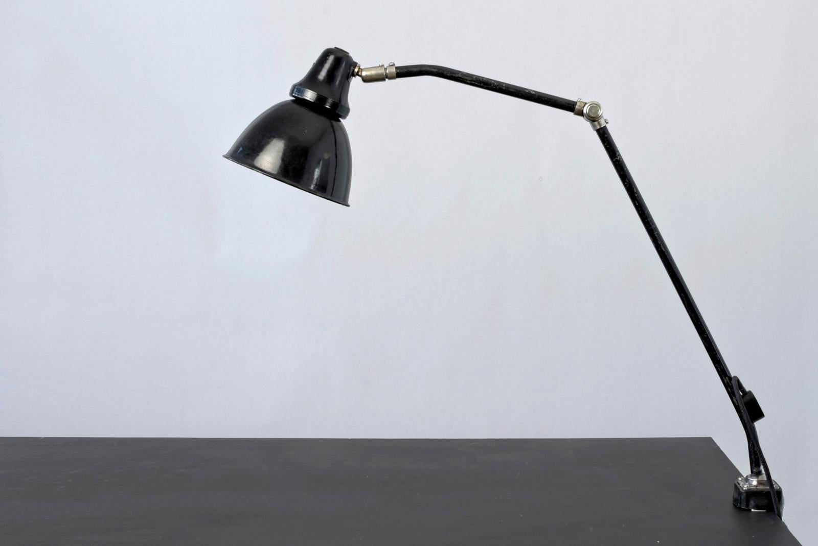H 90 cm W 80 cm D 18 cm

Material: painted sheet steel, nickel-plated brass, painted cast iron, bakelite shade holder and switch, enameled sheet iron shade, black textile-coated connection cable, one E 27 light point, switch integrated in shade