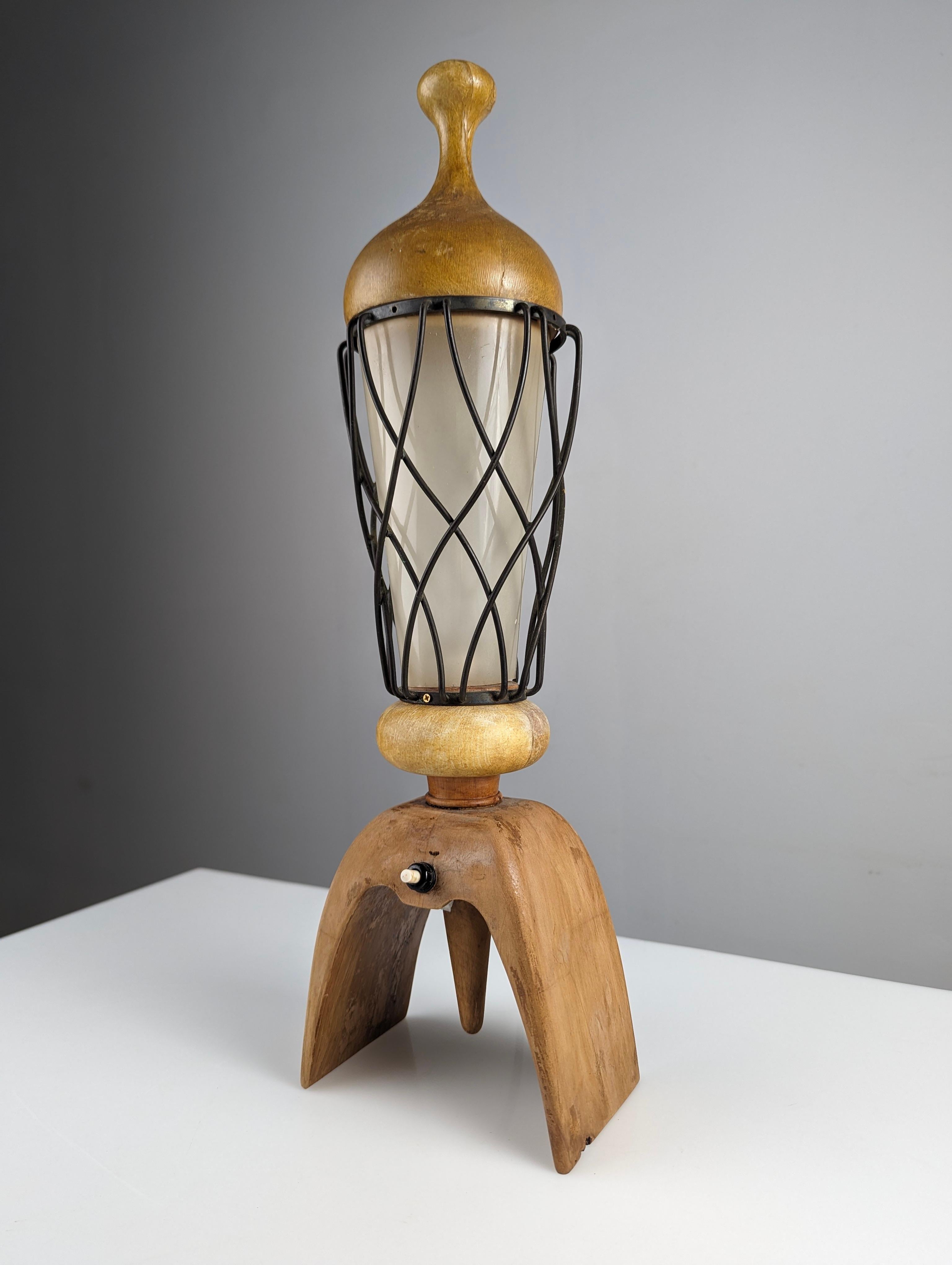 Lampe de table du grand designer italien Aldo Tura. Cette pièce allie le bois aux lignes courbes avec sa lanterne métallique croisée caractéristique protégeant le cylindre en acrylique. Une belle œuvre du design italien particulier d'Aldo Tura dans