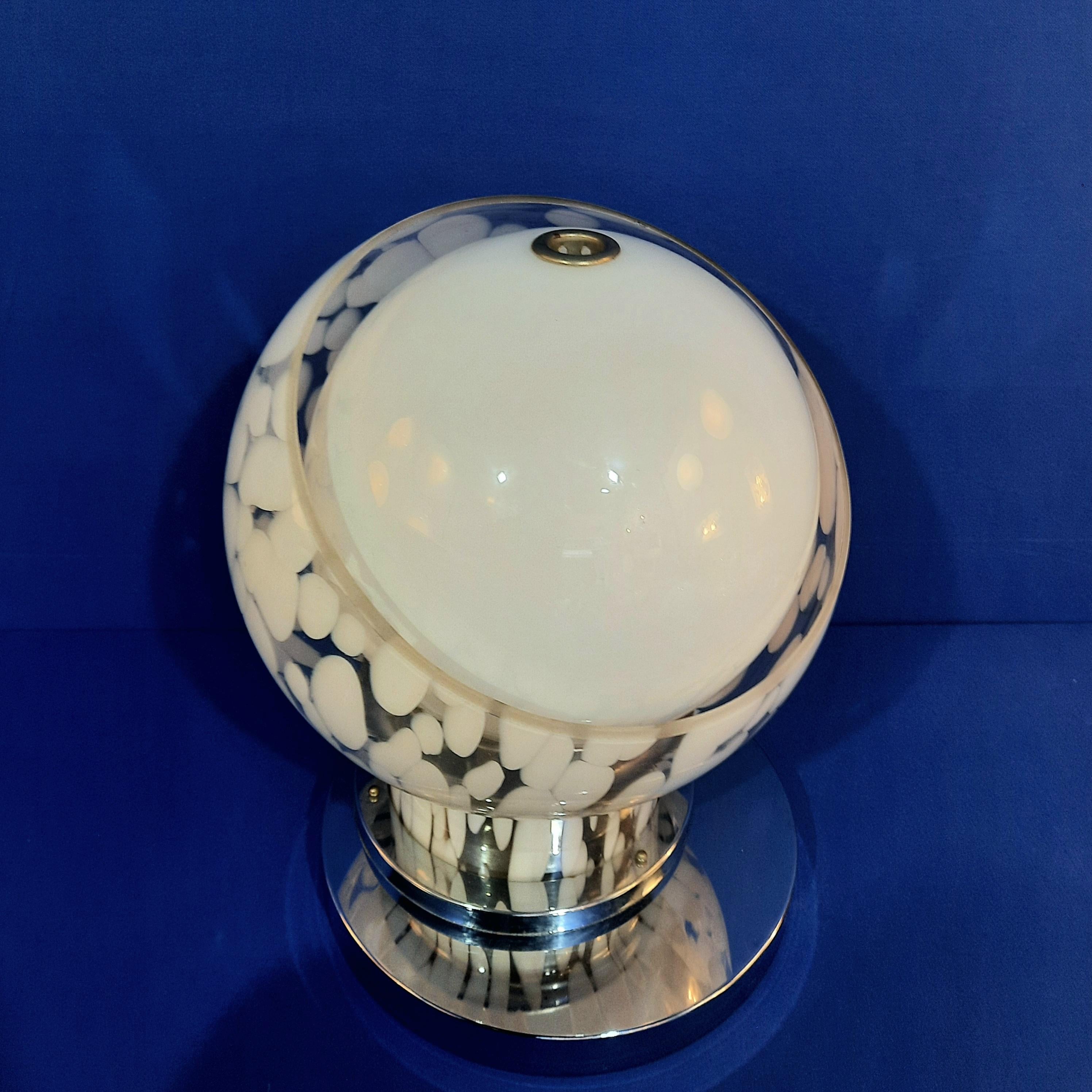 Cette lampe de table iconique a été conçue par Angelo Brotto et éditée par Esperia au début des années 1970.

Il est composé de deux pièces de verre. Le globule blanc opalin est d'abord inséré dans un globule 