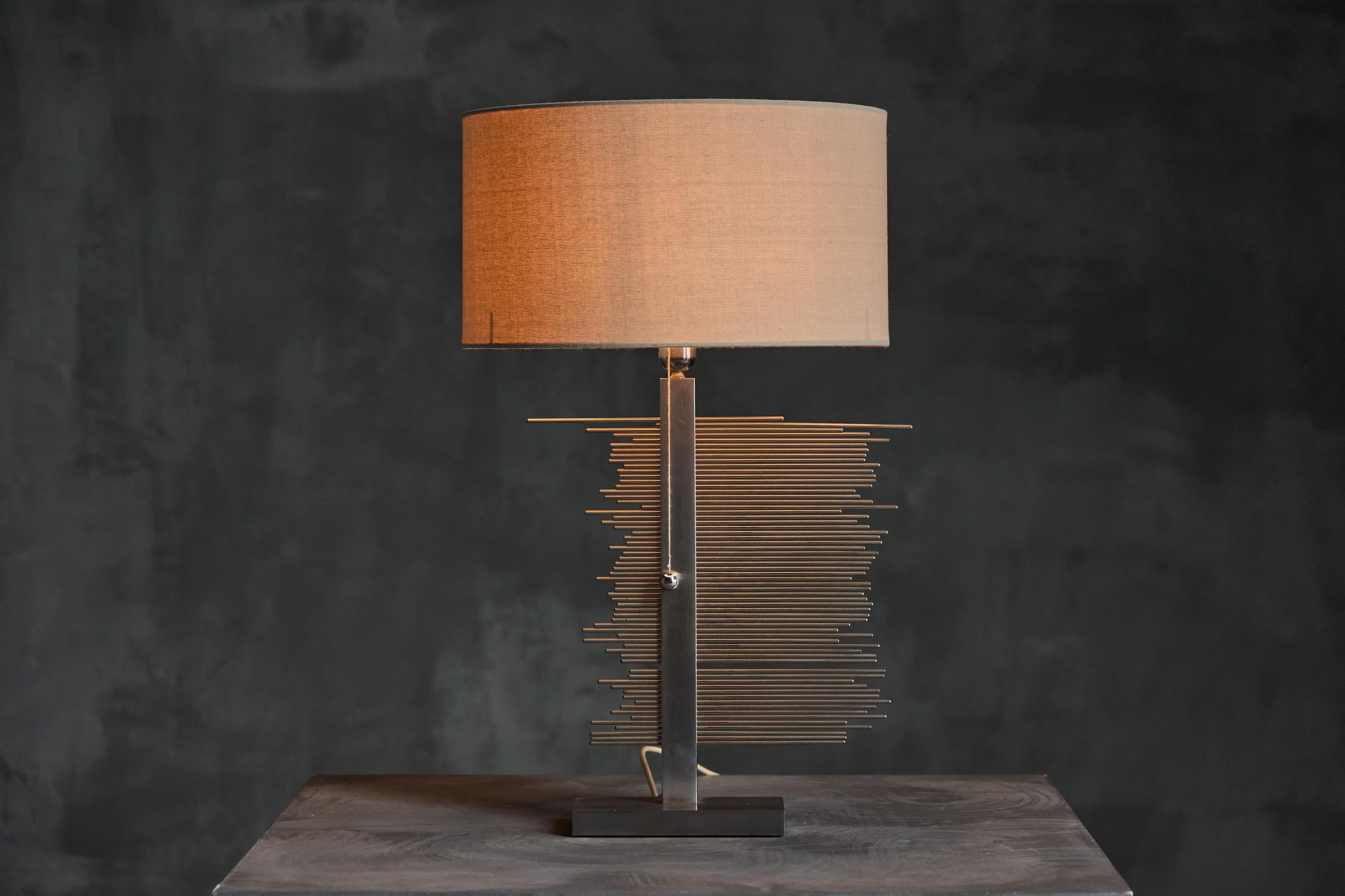 A rare 1970s Banci Firenze table lamp featuring a striking kinetic design with chrome metal rods. The adjustable rods allow for endless sculptural compositions, making each display unique. Its sleek geometric form is paired with a fabric shade,