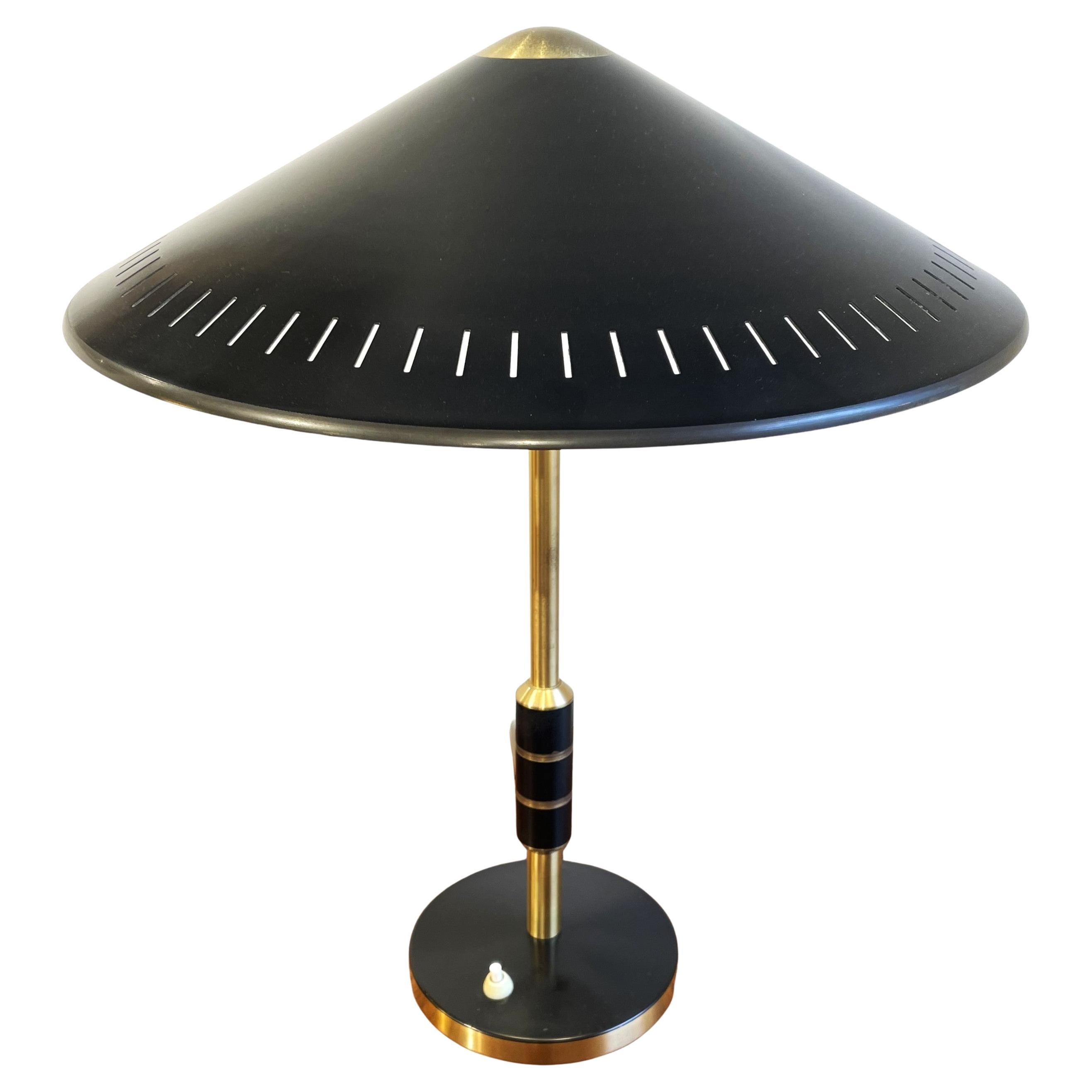 Très jolie lampe de table ou de bureau en laiton poli et métal laqué noir attribuée au designer danois Bent Karlby. Un design moderniste et classique à la fois qui produit un bel éclairage qui se diffuse également à travers les fentes de l'abat-jour