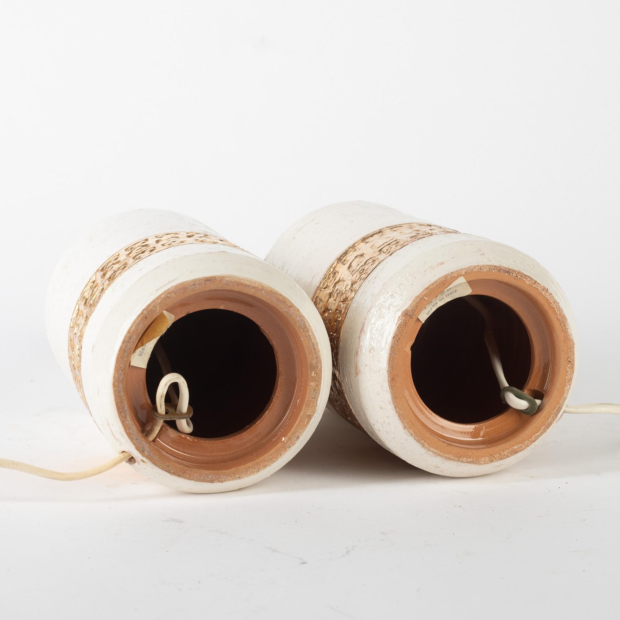 Bergboms (Sweden)
Table lamps, a pair, Bitossi for Bergboms, second half of the 20th century.
Ceramics, decorated with a light glaze and a gold-coloured border featuring a relief pattern. Labelled 18/25 Made in Italy. Height including lamp base