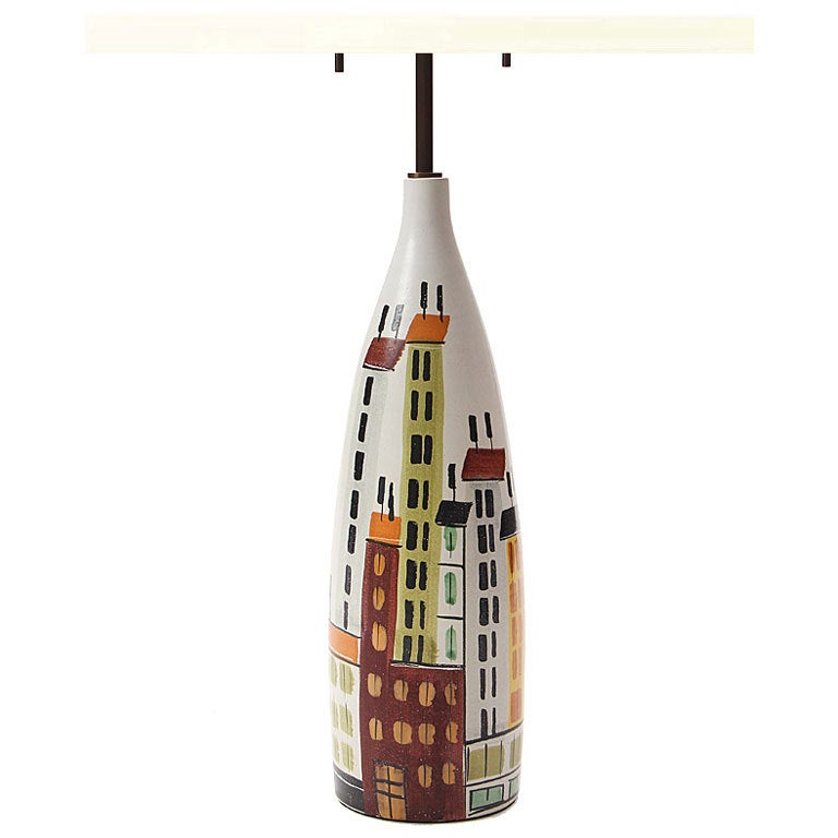 A hand thrown tapered ceramic table lamp with an apartment building and water tower motif. Designed by Bitossi, produced in Italy, circa 1950s.
 