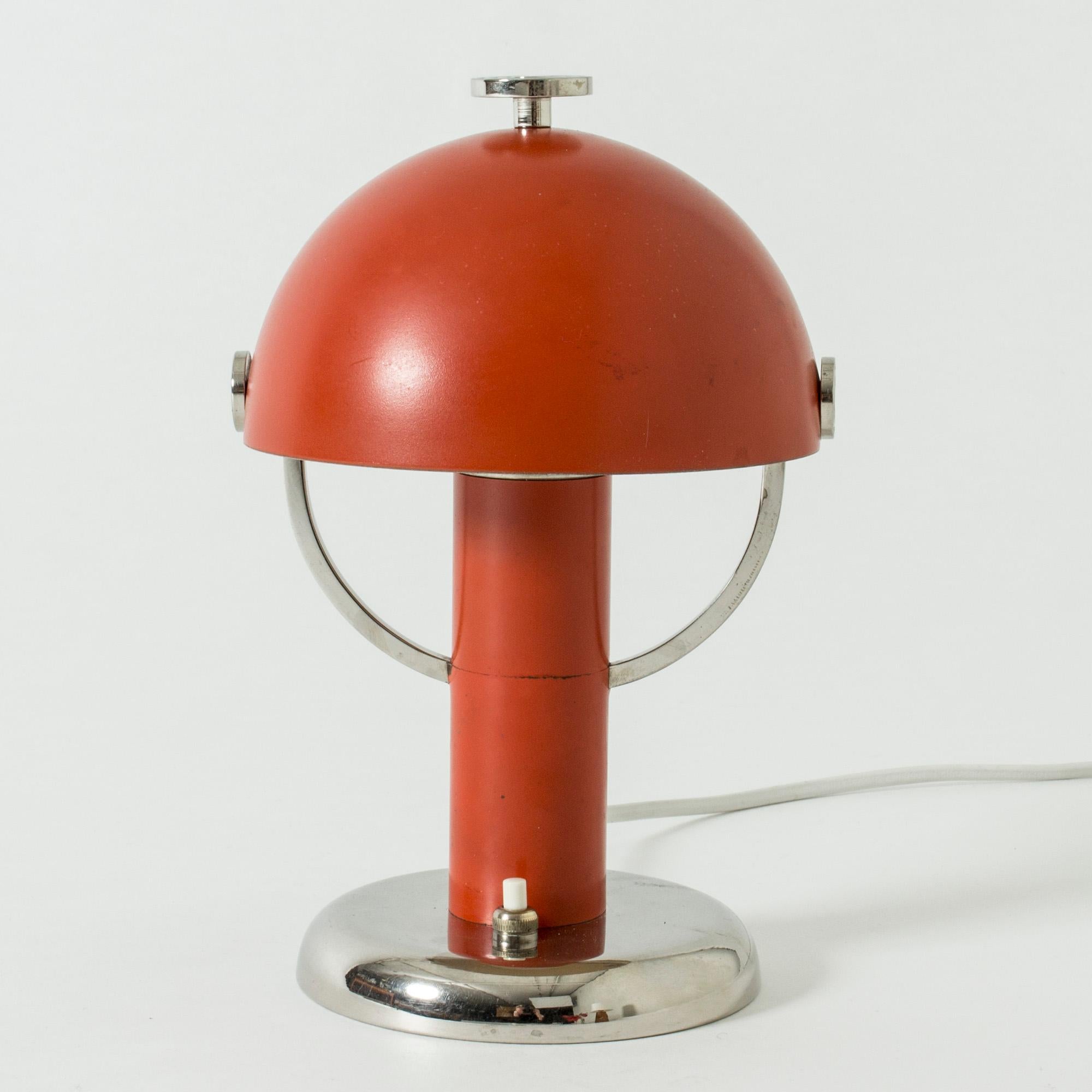 Gorgeous little table lamp by Bo Notini in a very functionalist design. The shade can be adjusted in various angles. Cool metal details against the red lacquer.