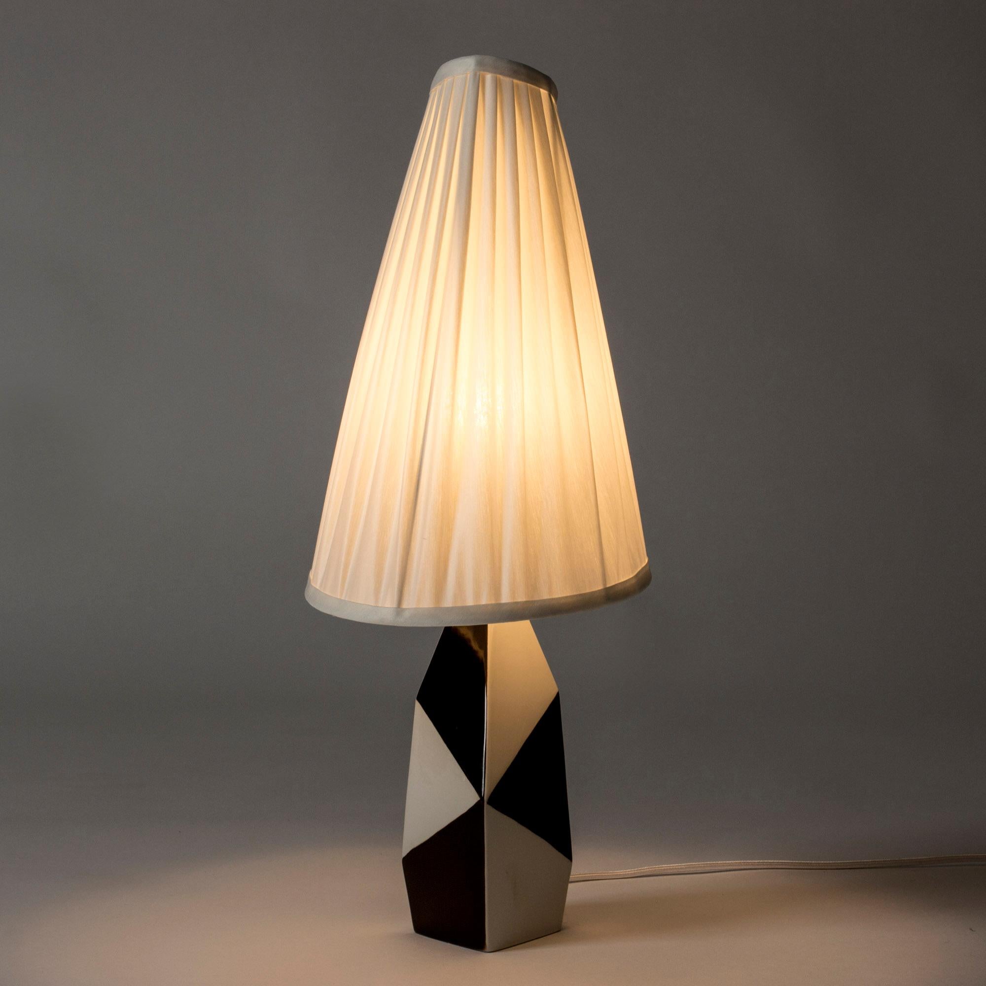Amazing stoneware table lamp by Carl-Harry Stålhane. Graphical, sculptural body with striking black and white decor. Asymmetric, pleated shade.

Carl-Harry Stålhane was one of the stars among Swedish ceramic artists during the 1950s, 1960s and