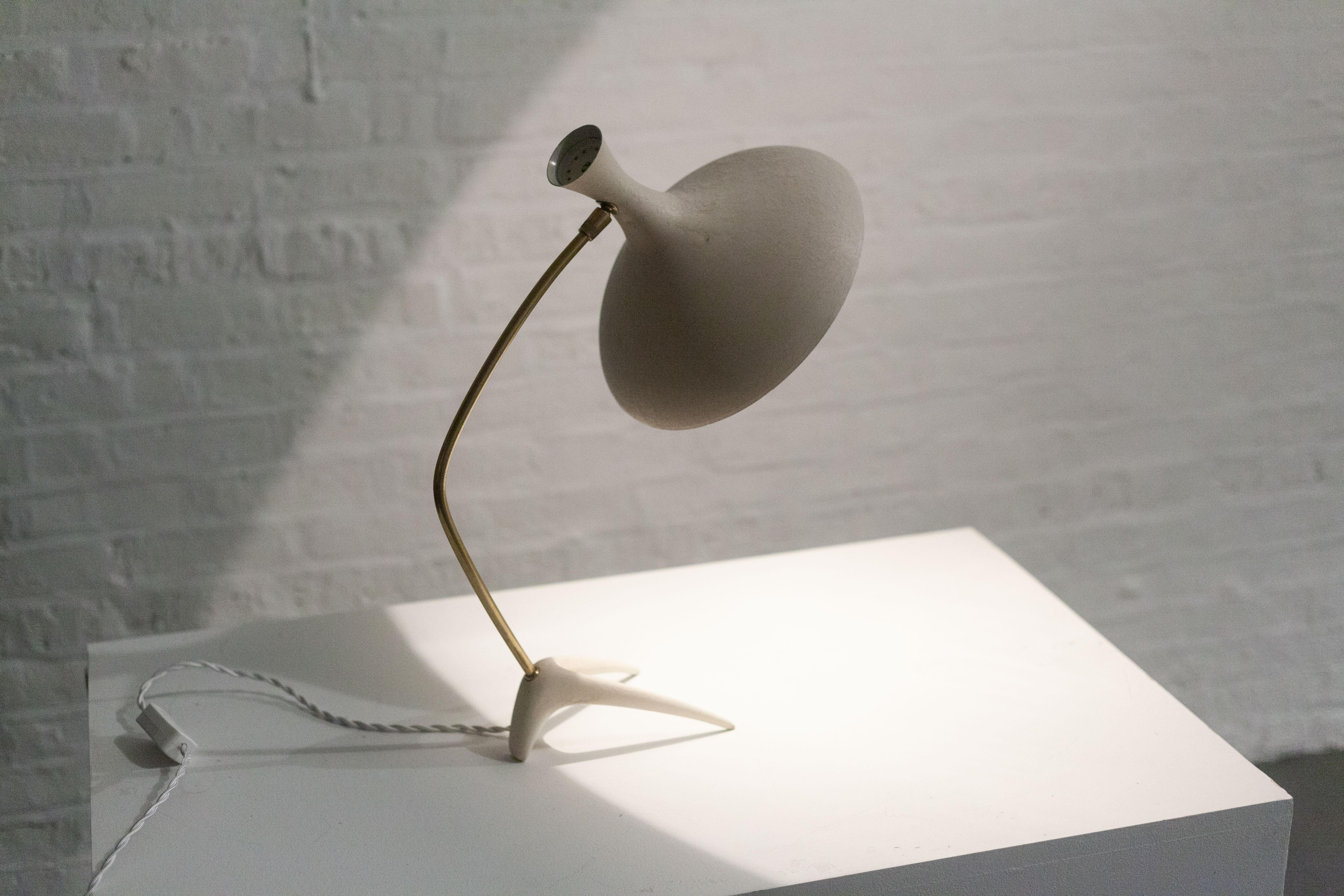 Imported from Germany, a mid-century 1950s lamp long attributed to Louis Kalff and now known to be Cosack Leuchten. 

The white metal shade with its biomorphic, organic form has an angelic trumpet like shape and its original crepe textured paint.