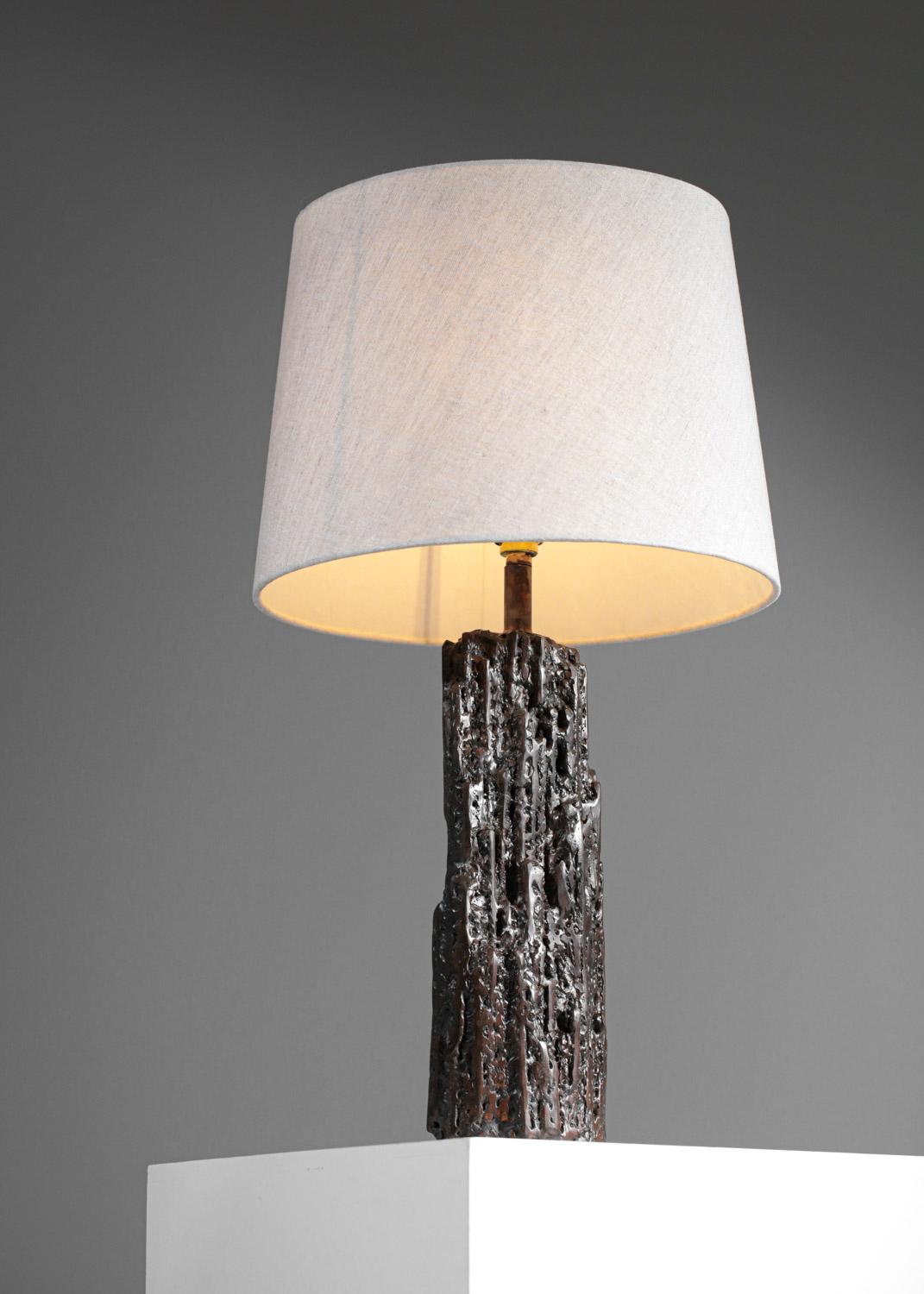 This table lamp in a brutalist style was created by the artist Donna. Its imposing base in patinated metal was handmade and requires a unique meticulous and precise work. Designer sober, elegant and very decorative. Presence of the artist's