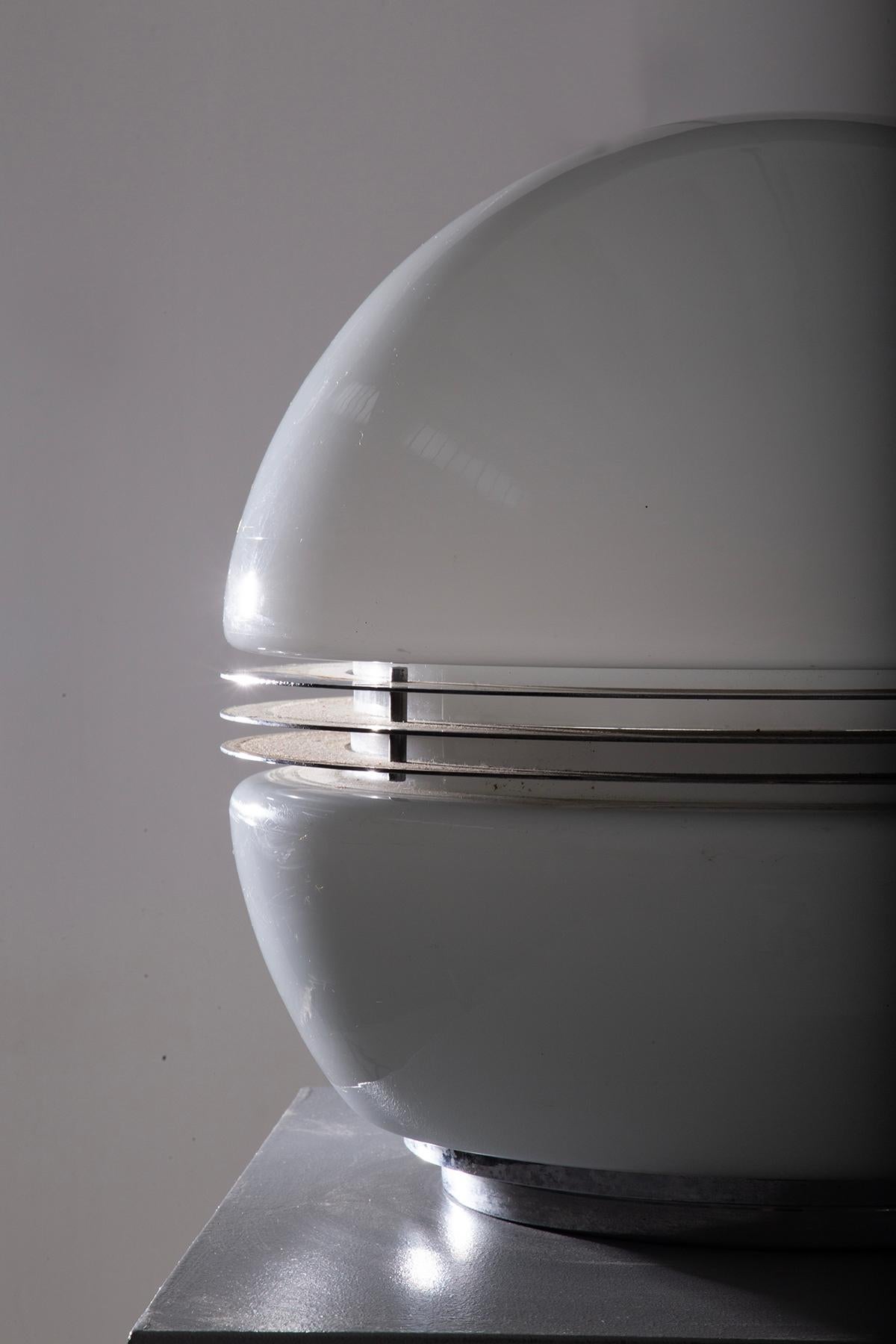 Step back into the innovative flair of the 1970s with this stunning spherical table lamp by Enrico Tronconi. This lamp perfectly embodies the Space Age era's fascination with futuristic yet timeless designs. Comprising two expertly crafted white