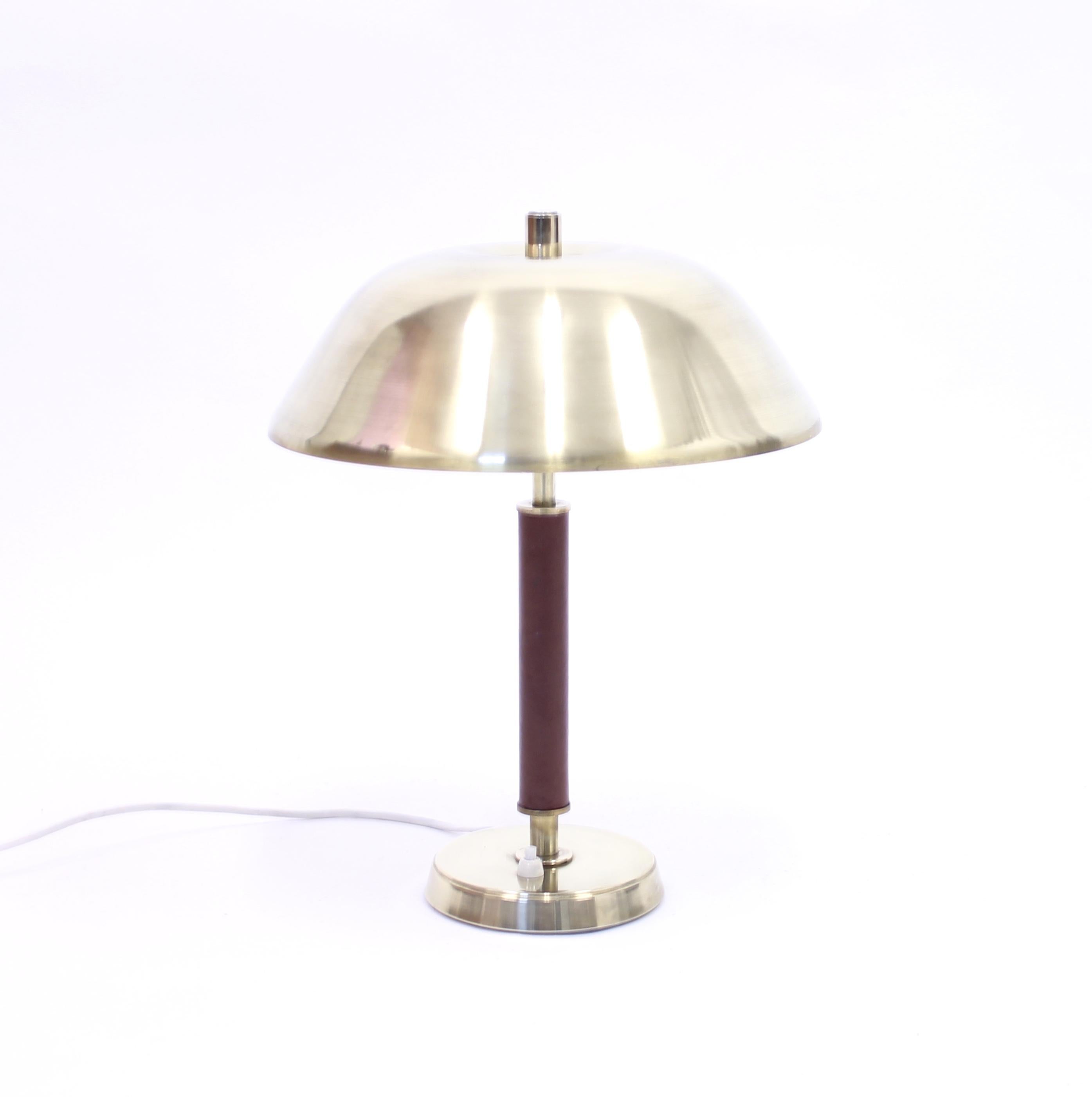 Brass table lamp with leather clad stem manufactured by Swedish firm Falkenbergs Belysning in the 1960s. Marked with sticker under the base. Very good condition with minor ware.