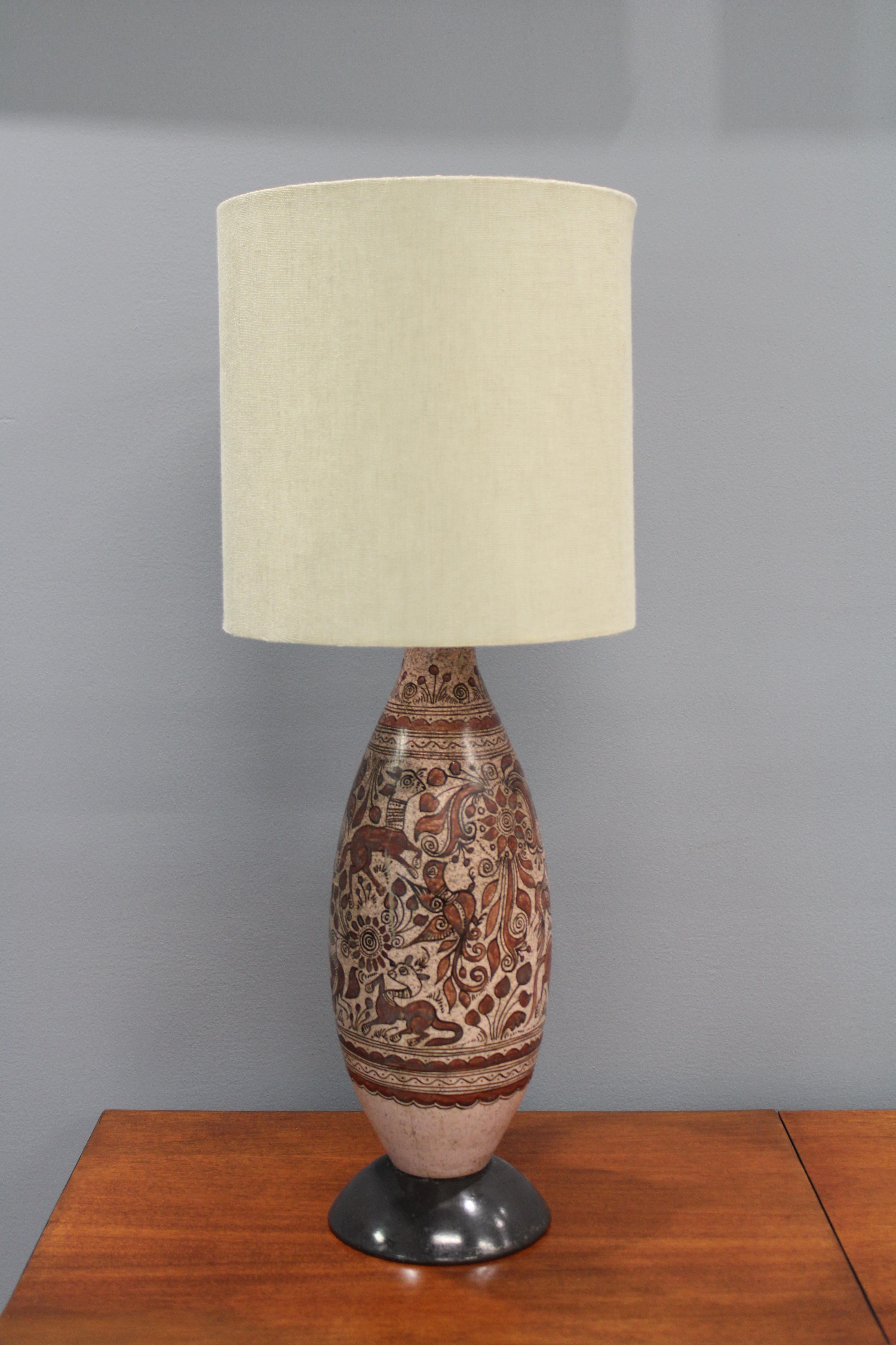 Une grande lampe de table par Felix Tissot circa 1960s. Cette pièce est la décoration parfaite pour votre chambre. L'abat-jour n'est pas inclus.
Felix Tissot était un céramiste français qui a travaillé dans l'industrie cinématographique au début du