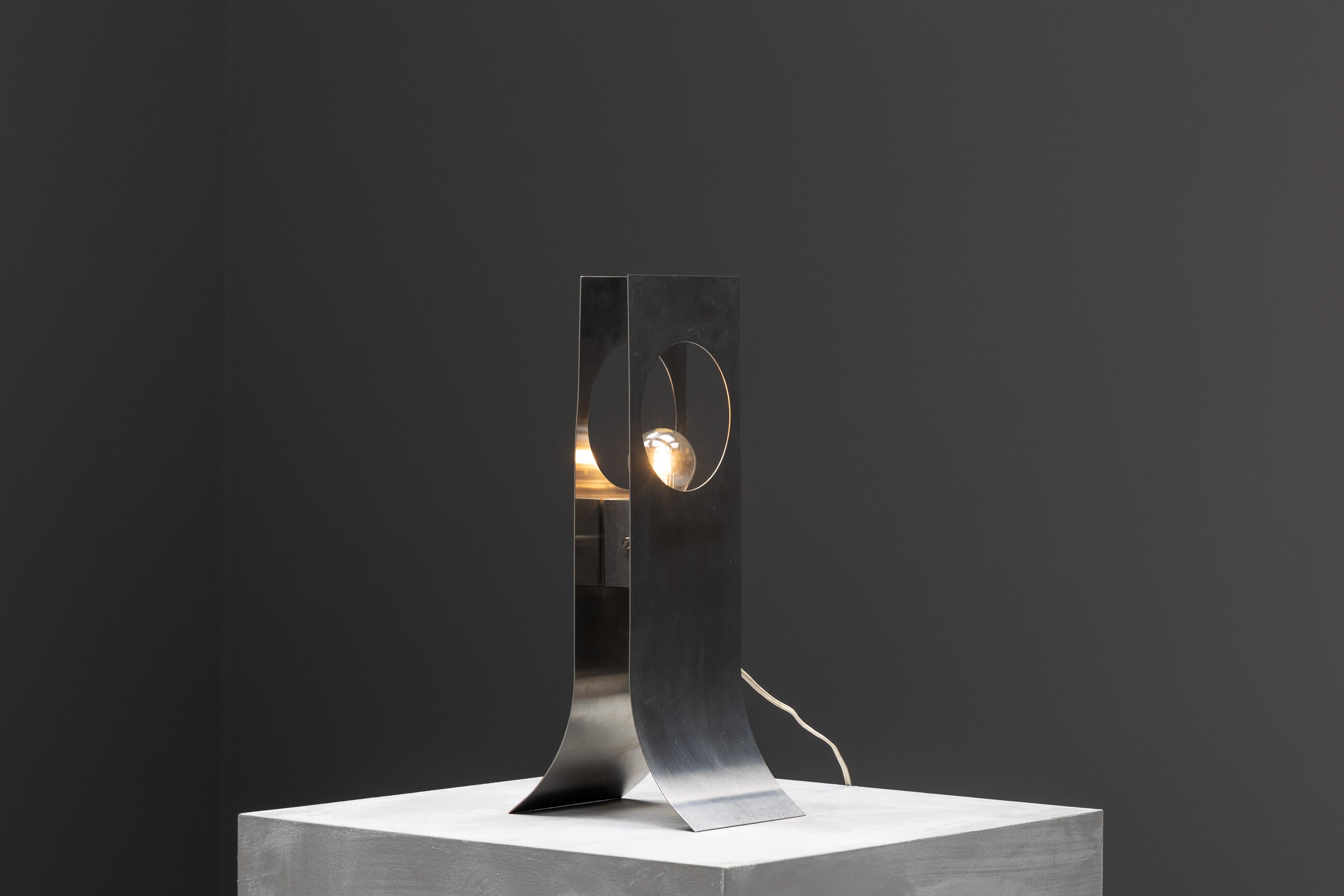 Lampe à poser en acier inoxydable de François Monnet, une pièce iconique présentée pour la première fois en 1969 et éditée par Kappa. Il incarne l'essence du design français de l'ère spatiale, caractérisé par sa finition chromée épurée et sa