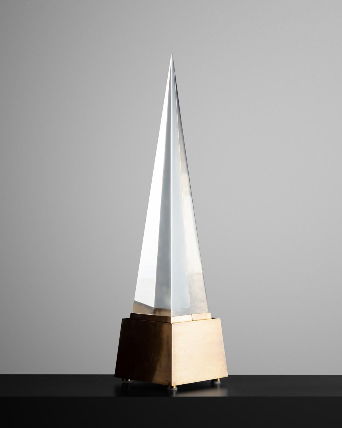Lucite pyramid mounted to an angled base of patinated brass. Signed on the base.


  
 