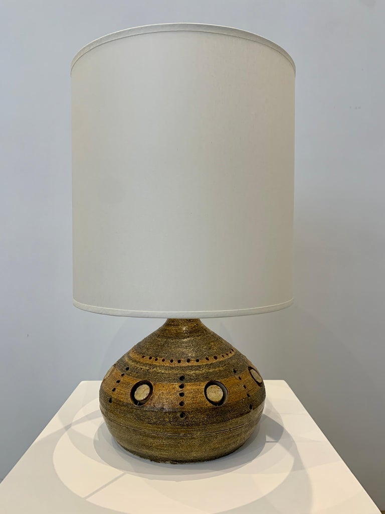 Georges Pelletier is famous Belgian ceramist who was active in Paris most of his career. His lamps are based on earth colouration with free standing elements that create a decorative pattern, typical of his work. The present lamp is a small elegant