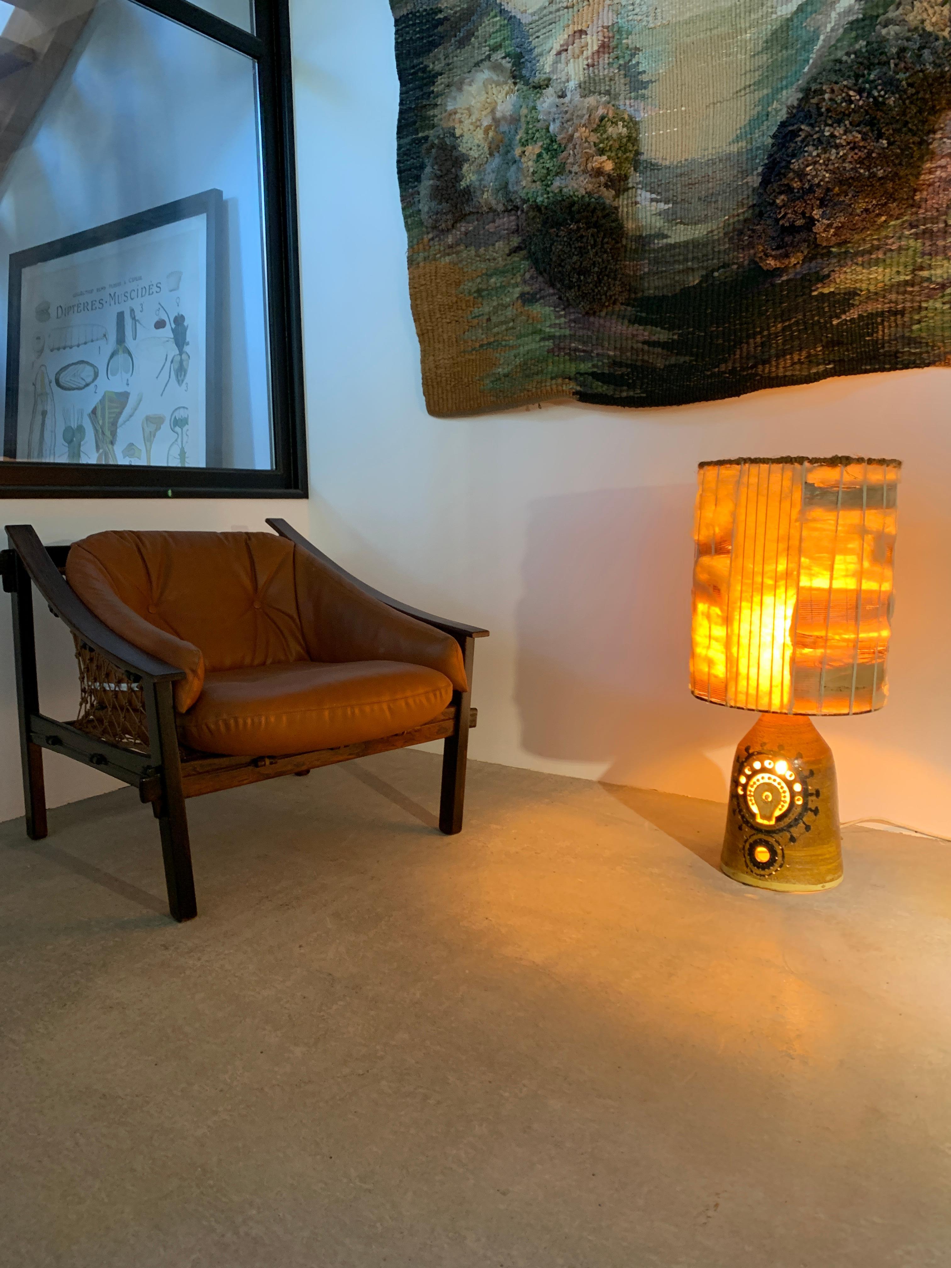 Imposing sculpted ceramic lamp by Georges Pelletier, Unique Piece.

This striking ceramic lamp features a bold, sculptural form with a central motif that evokes an imaginary mechanism, blending primitive aesthetics with a steampunk spirit. 
Equipped