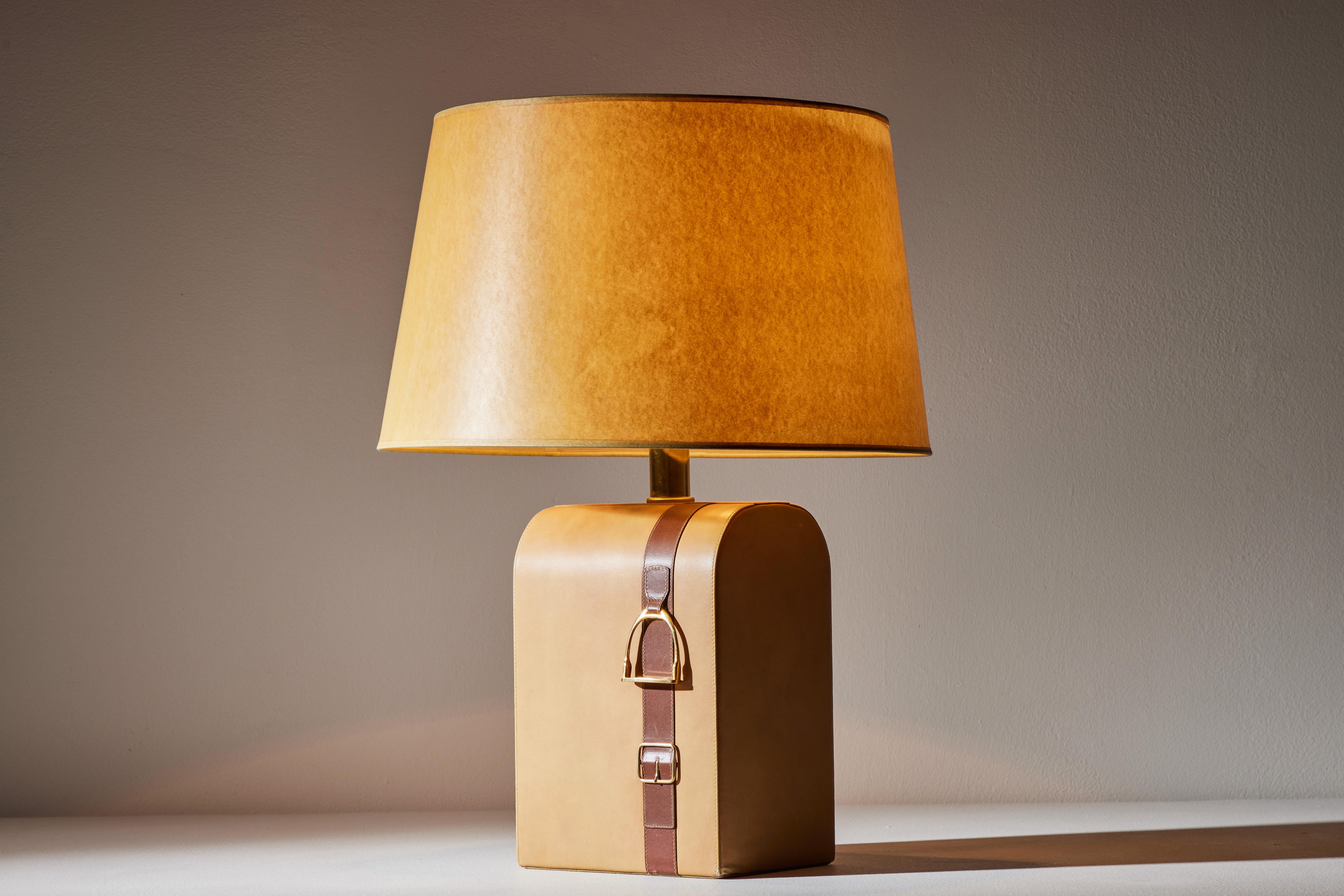 Table lamp by Gucci. Manufactured in Italy, circa 1980s. Leather, brass, parchment shade. Original European We recommend one E26 60w maximum bulb. Bulbs provided as a one time courtesy. Retains original manufacturer's stamp.