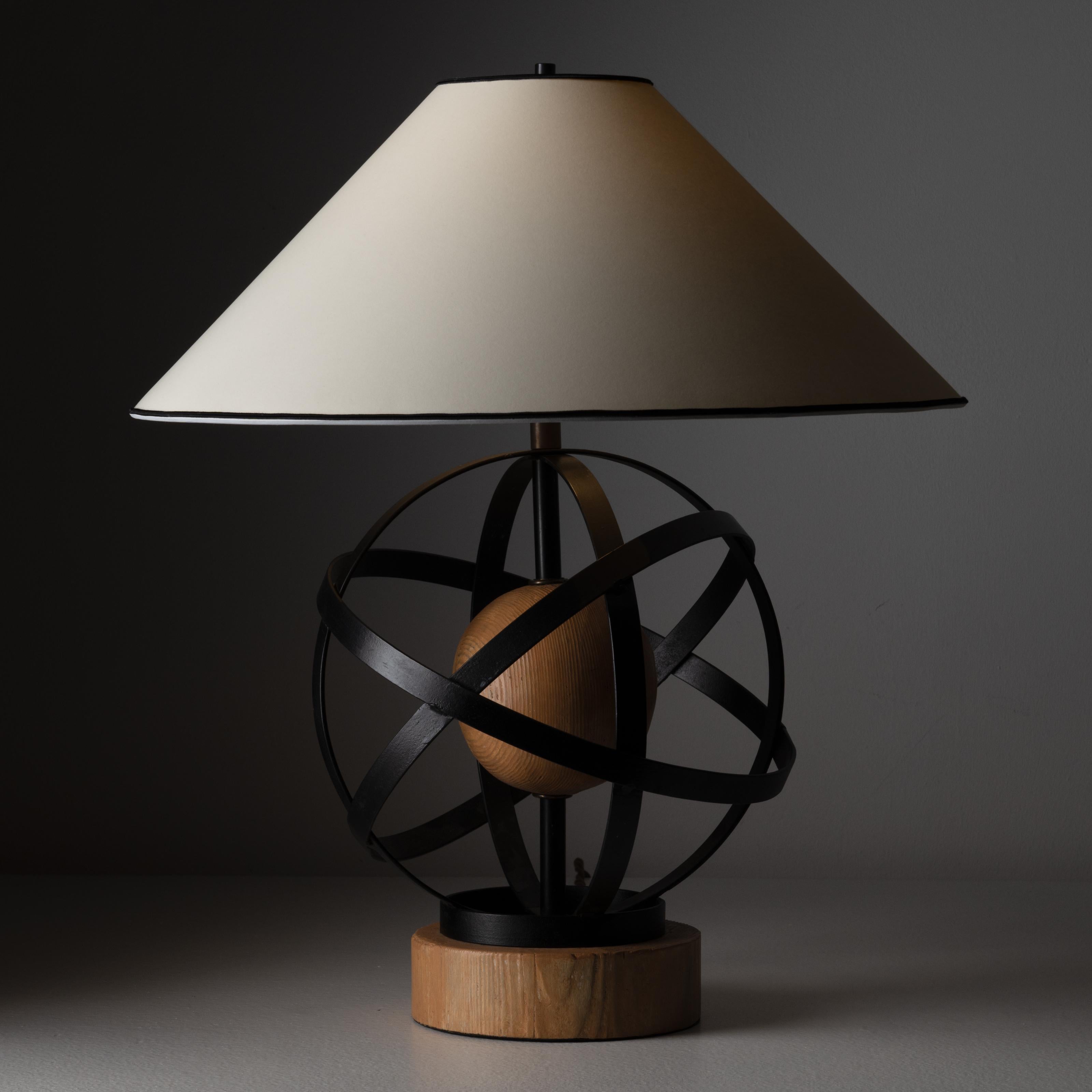 Table lamp by Heifetz. Designed and manufactured in the United States, circa 1950. Wood and iron table lamp, possessing an almost molecular shape of wrapped iron, with a sturdy wooden base. The shade is a newly fabricated off-white linen with a