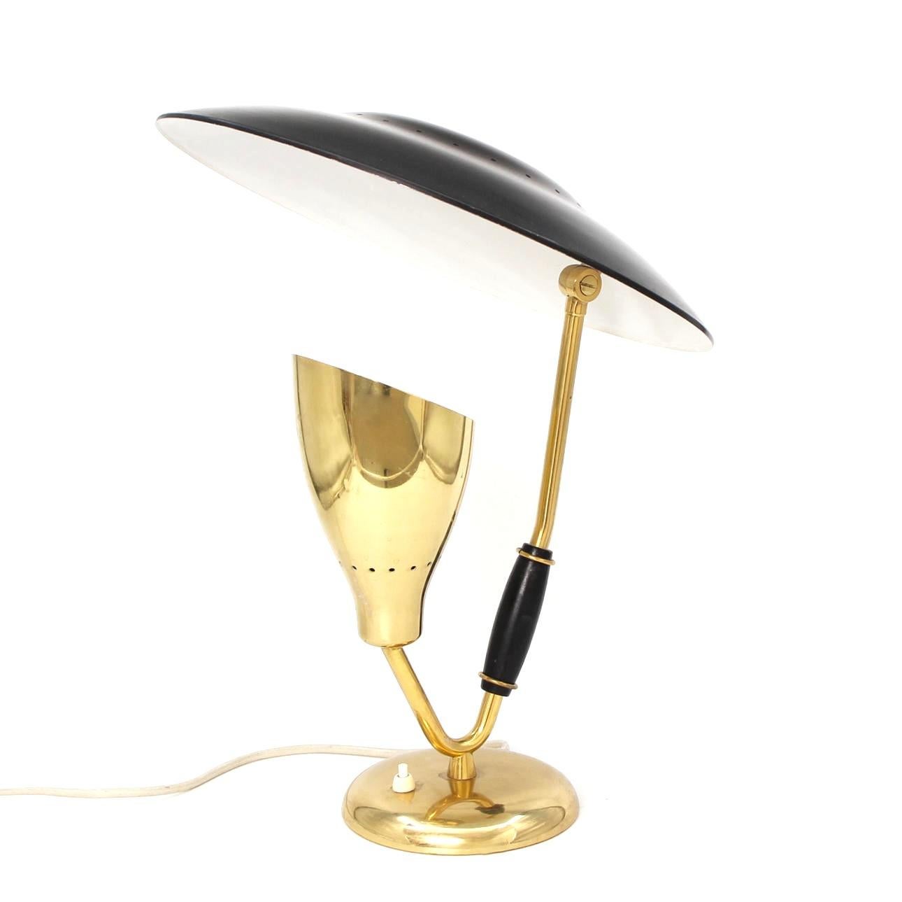 Very beautiful and rare table or desk lamp in polished brass in sublime golden color and black lacquered metal as well as the wooden handle by the great Danish lamp designer Svend Aage Holm Sørensen. Modernist and classic design at the same time,