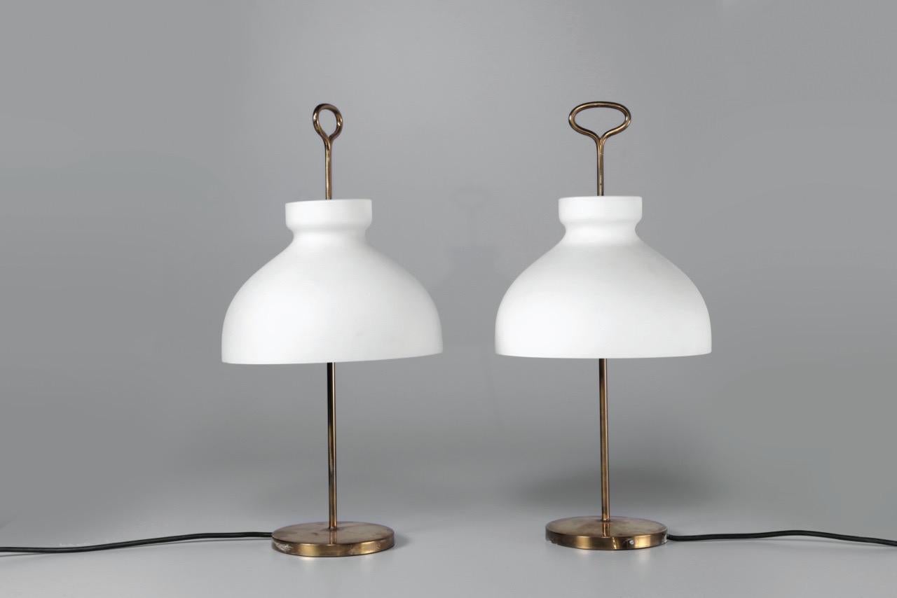 A set of two table lamps with a brass construction and satined opaline glass. 
Dimension / H.55 cm ø 30cm
Design / Ignazio Gardella 1956
Manufacturer / Azucena Italy.
 