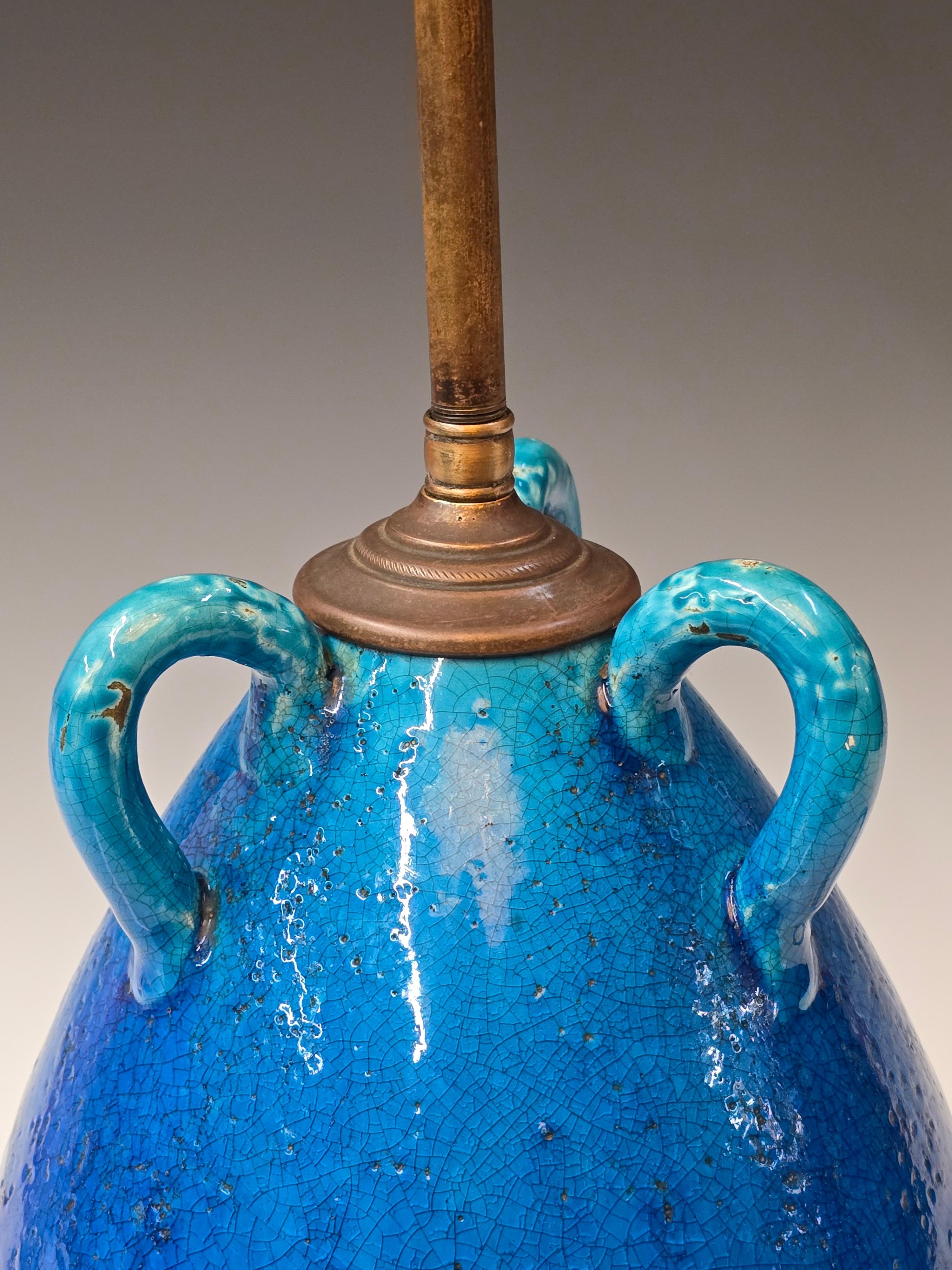 A hand thrown and glazed earthenware lamp by noted French ceramicist Jean Besnard(1889-1958).  A beautiful clear turquoise flambe glaze that fades into a darker blue over a turquoise that has more of a volcanic texture.   Overall the lamp has a