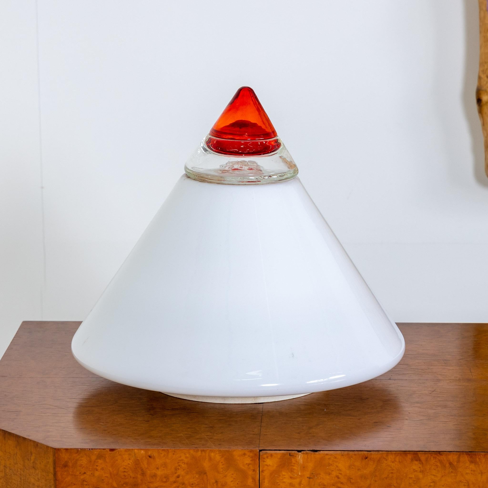 Cone-shaped table lamp made of white glass and red lace. Label on the side 