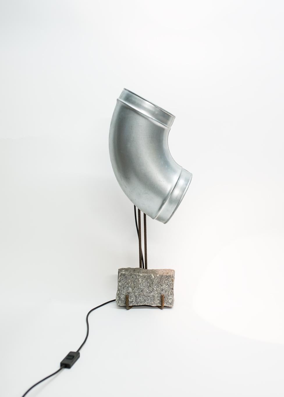 Table lamp is presented by Galerija VARTAI

Table lamp by Lucas Muñoz Muñoz is produced of construction materials (galvanised steel, steel and granite brick)

Three simple construction site elements combined into a table lamp that can take