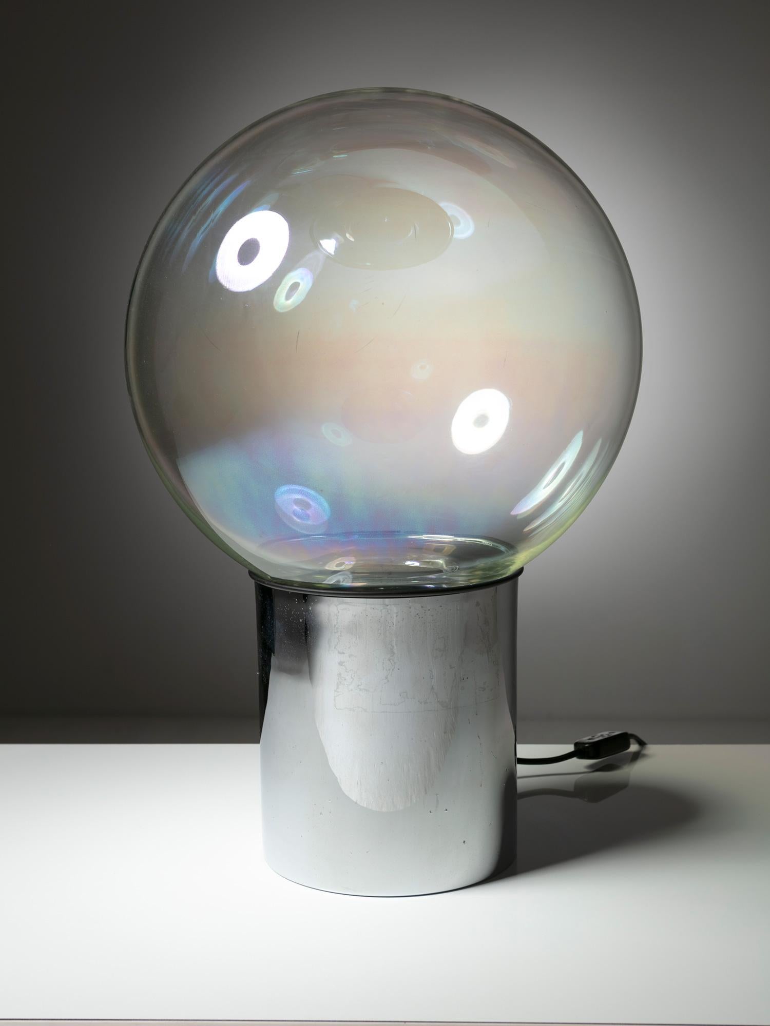 Grande sphère en verre irisé soutenue par une base chromée.