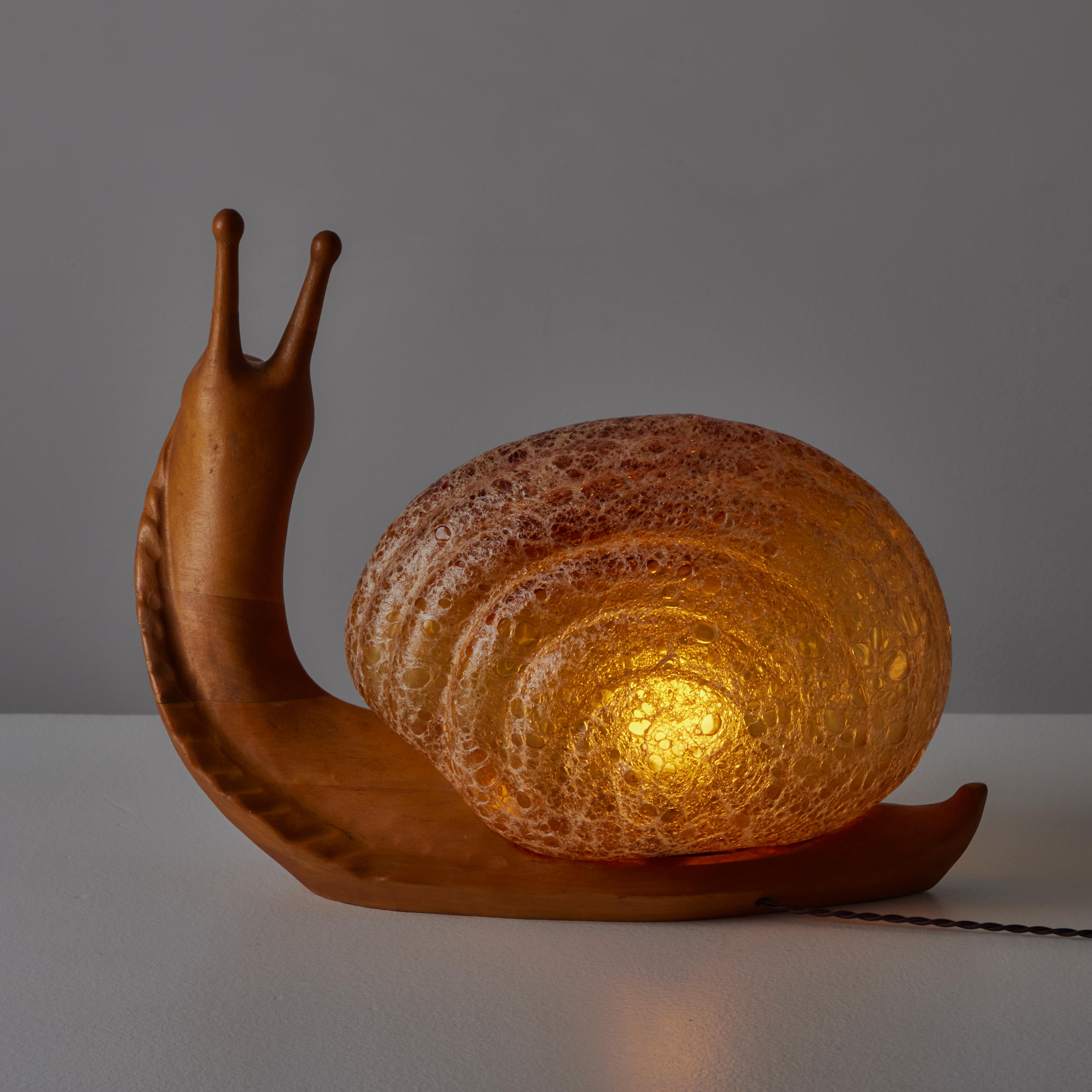 Lampe à poser Snail de Marzio Cecchi pour Dimensione Fuoco. Conçus et fabriqués en Italie, circa les années 1970. Un corps en bois sculpté associé à un diffuseur en verre texturé. Signature gravée sur la face avant du bois. Contient une seule