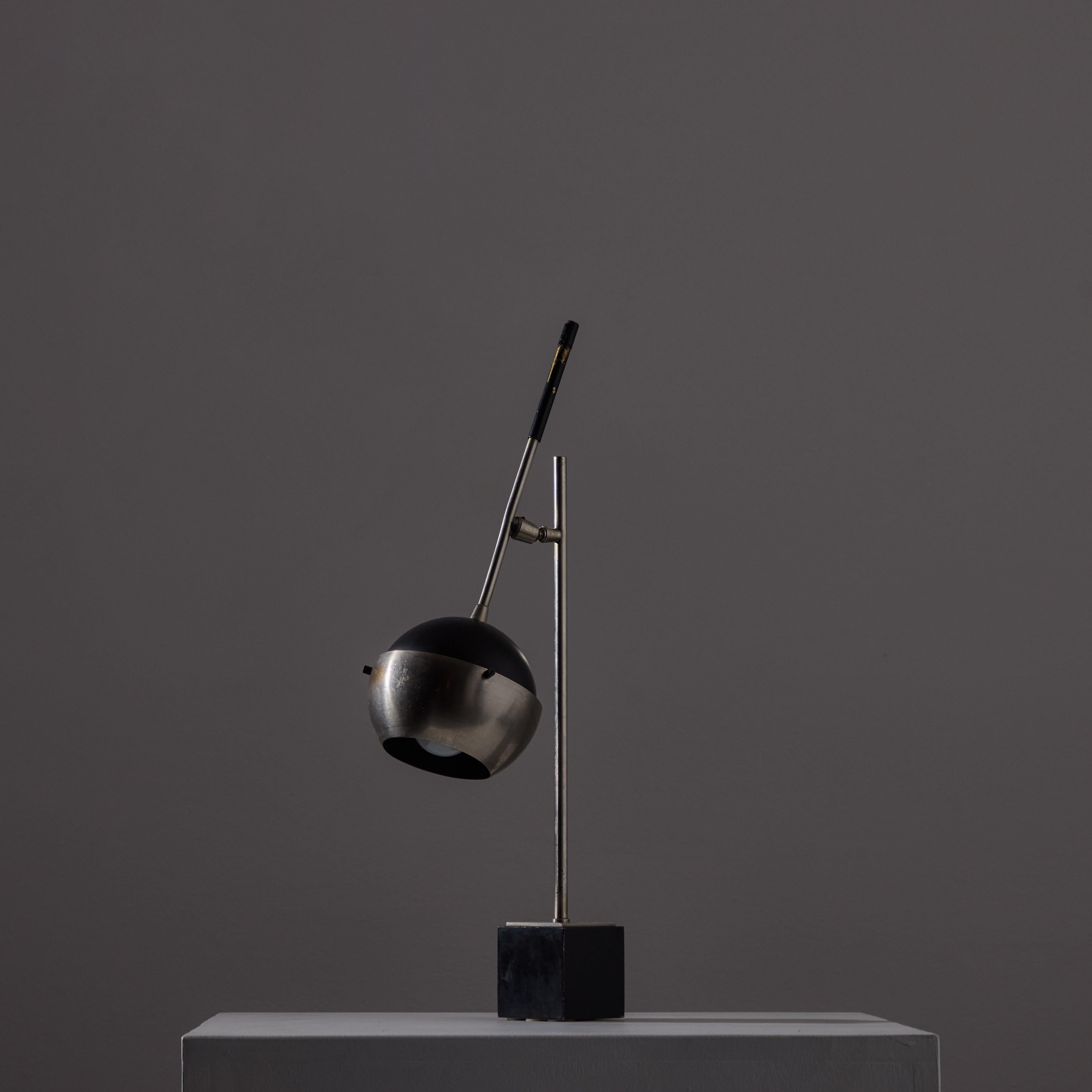 Table Lamp by Oscar Torlasco for Lumi. Designed and manufactured in Italy, circa the 1950s. Petite scale comprising of a brushed aluminum front cap, black inner cap, and a weighted enameled base. Brush aluminum details throughout. The arm of this
