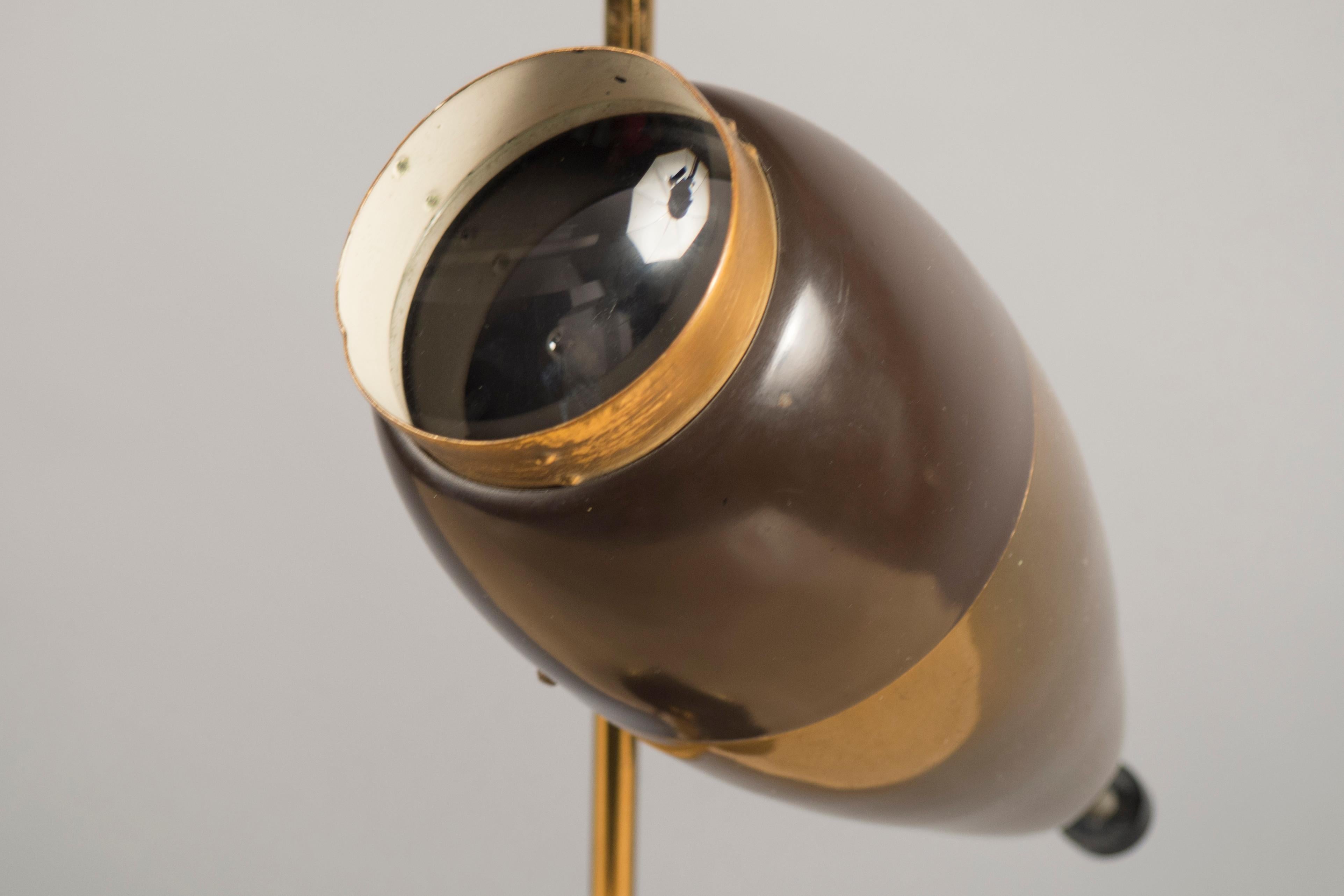 Brass with painted and enameled brown trim and an adjustable glass lens. Literature: Domus 433 and C. & P. Fiell’s 1000 Lights, model pictured on page 331.
    