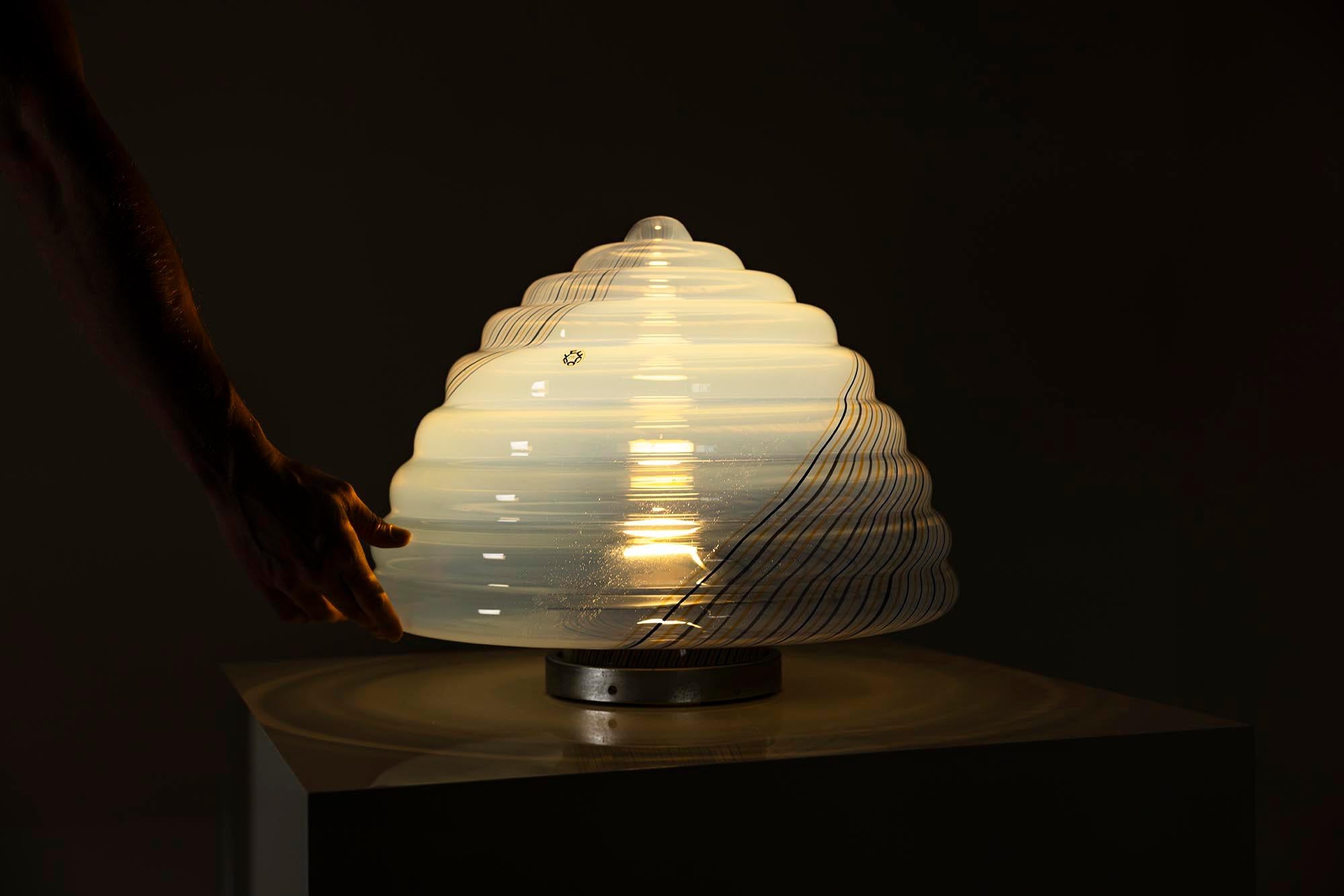 Los diseños de Roberto Pamio & Renato Toso suelen combinar líneas claras con un refinado juego de materiales y luz. Esta lámpara de sobremesa, producida por Leucos en Italia, ejemplifica su enfoque colaborativo del diseño de iluminación